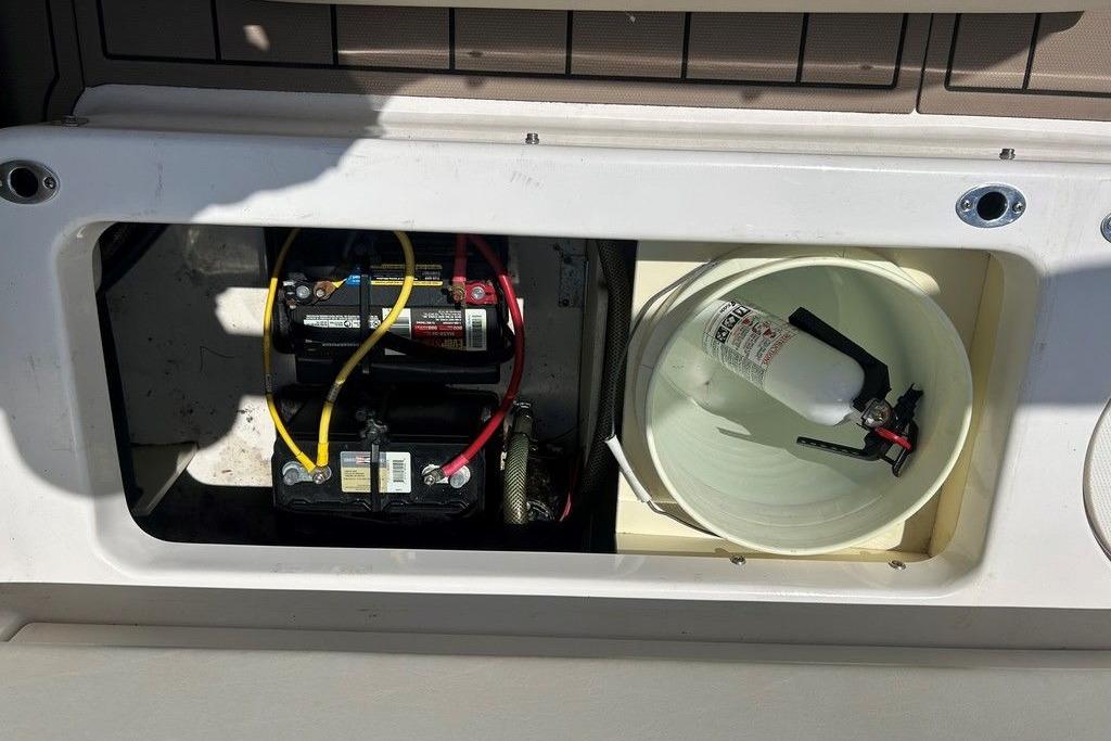 2017 Robalo R200ES boat battery compartment with fire extinguisher and wiring.
