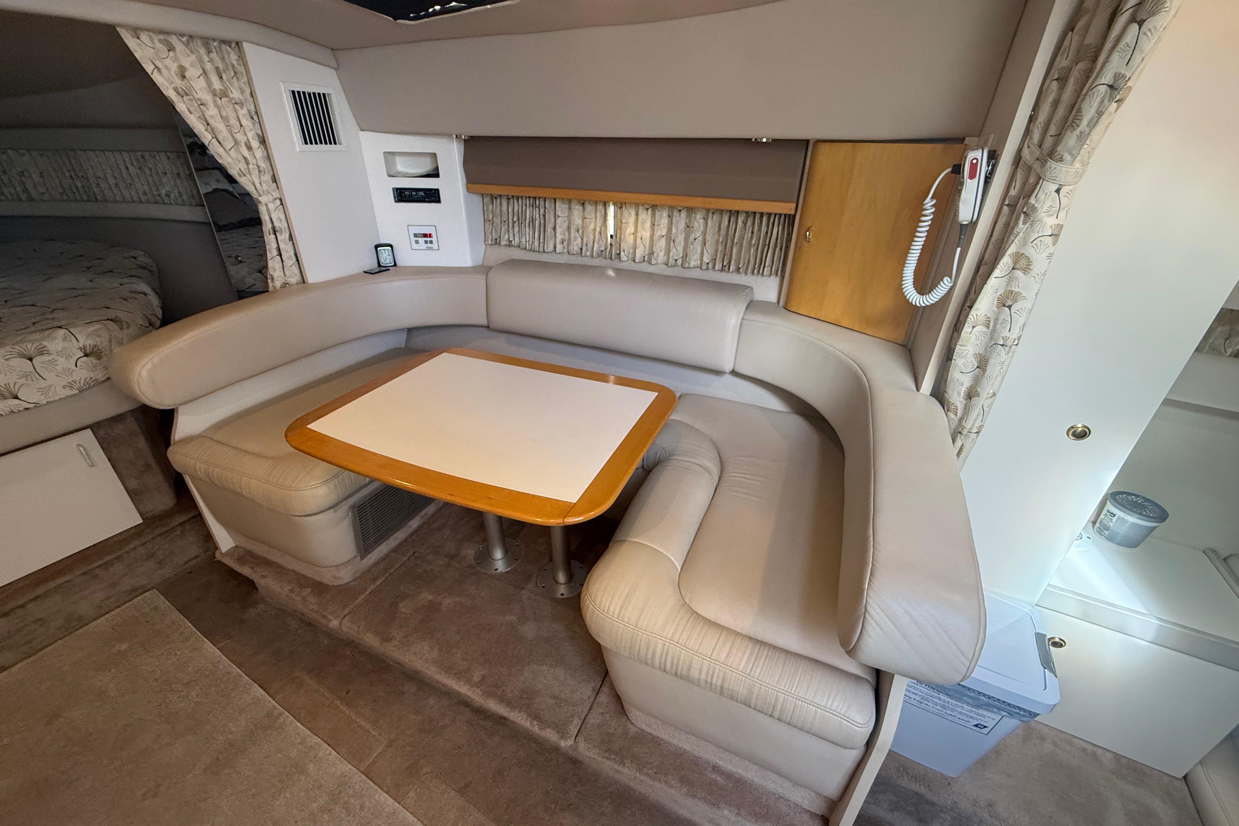Interior of a 1999 Formula 34 Performance Cruiser with beige seating and a wooden table.