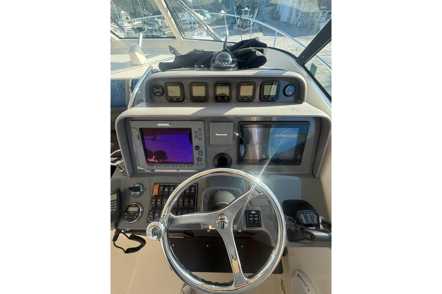 Helm of 2010 Pursuit OS 375 Offshore boat with navigation equipment and steering wheel.