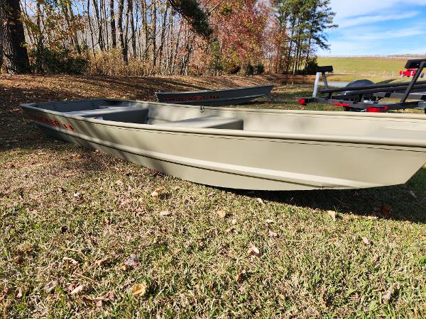 2025 Tracker Grizzly 1436 Utility boat on grassy field, surrounded by autumn trees.