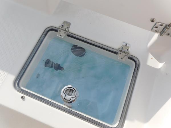 Livewell on 2025 Sailfish 232 CC boat, featuring a clear lid and secure latch.