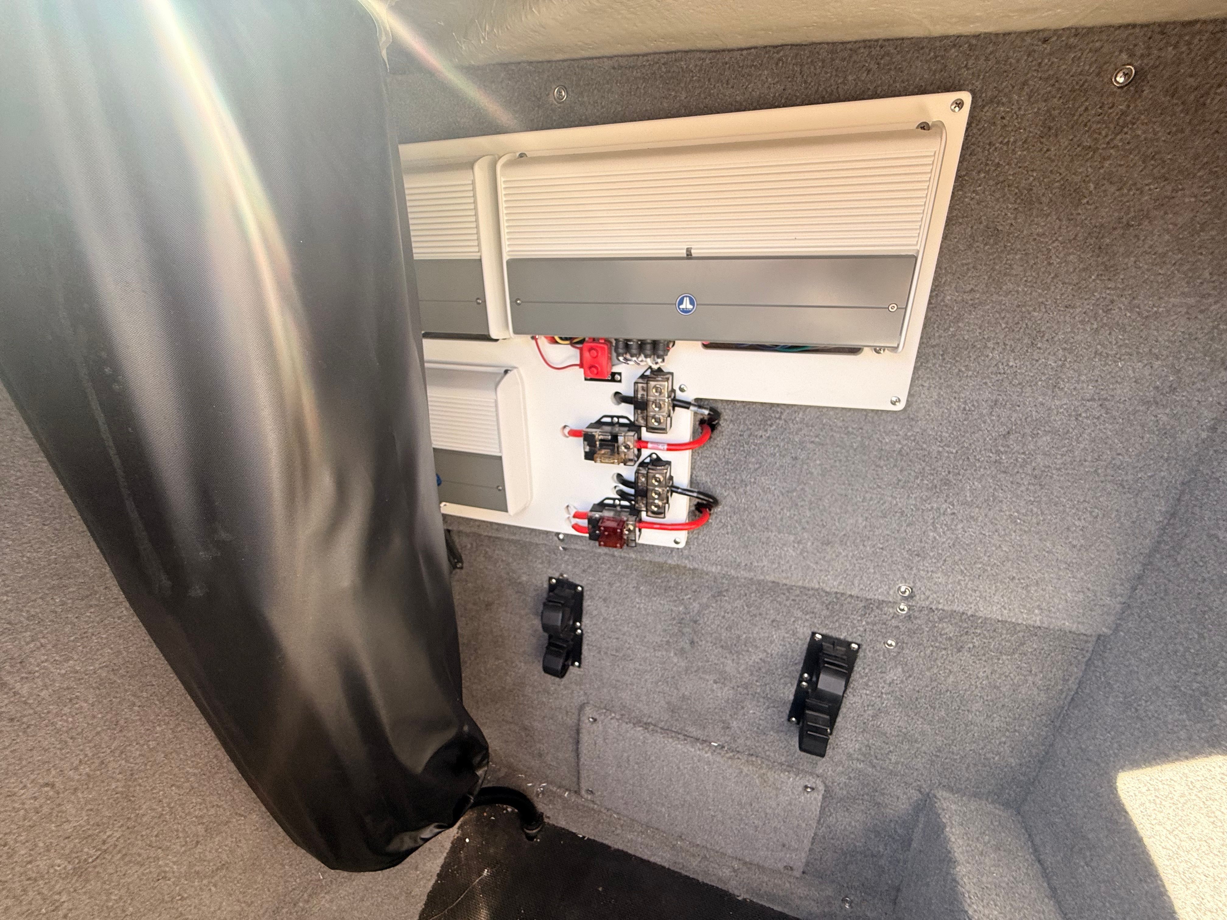 The interior of a 2019 Cobalt R7 Surf boat features electrical panels and gray upholstery.