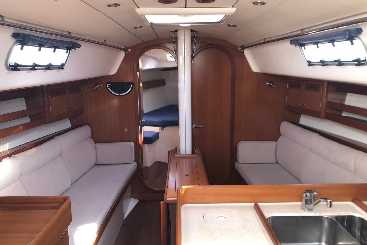 Interior of 2007 J Boats J/122 sailboat, featuring cozy seating and wooden cabinetry.