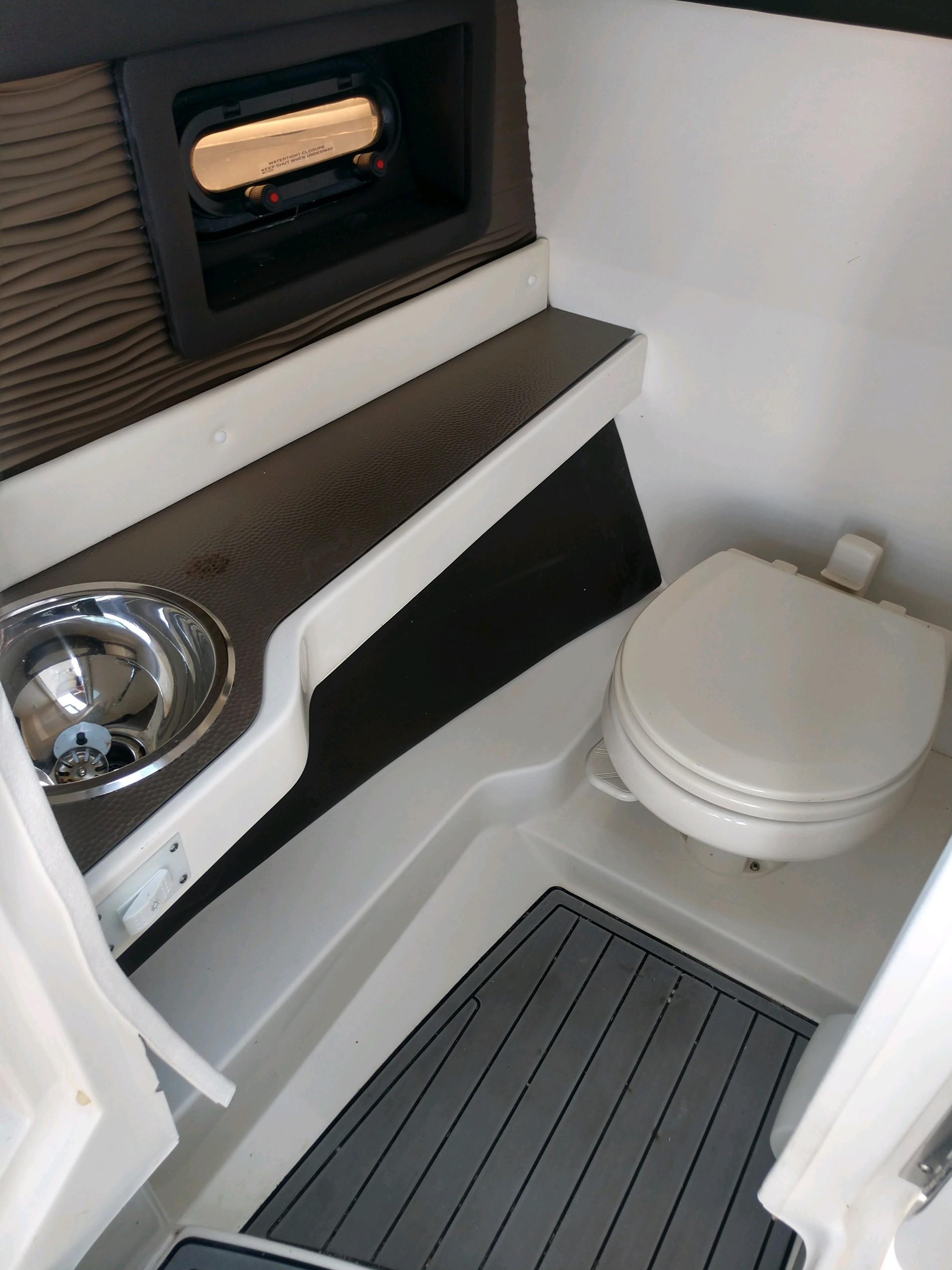 2018 Sea Ray SLX 280 boat interior bathroom with sink and toilet.