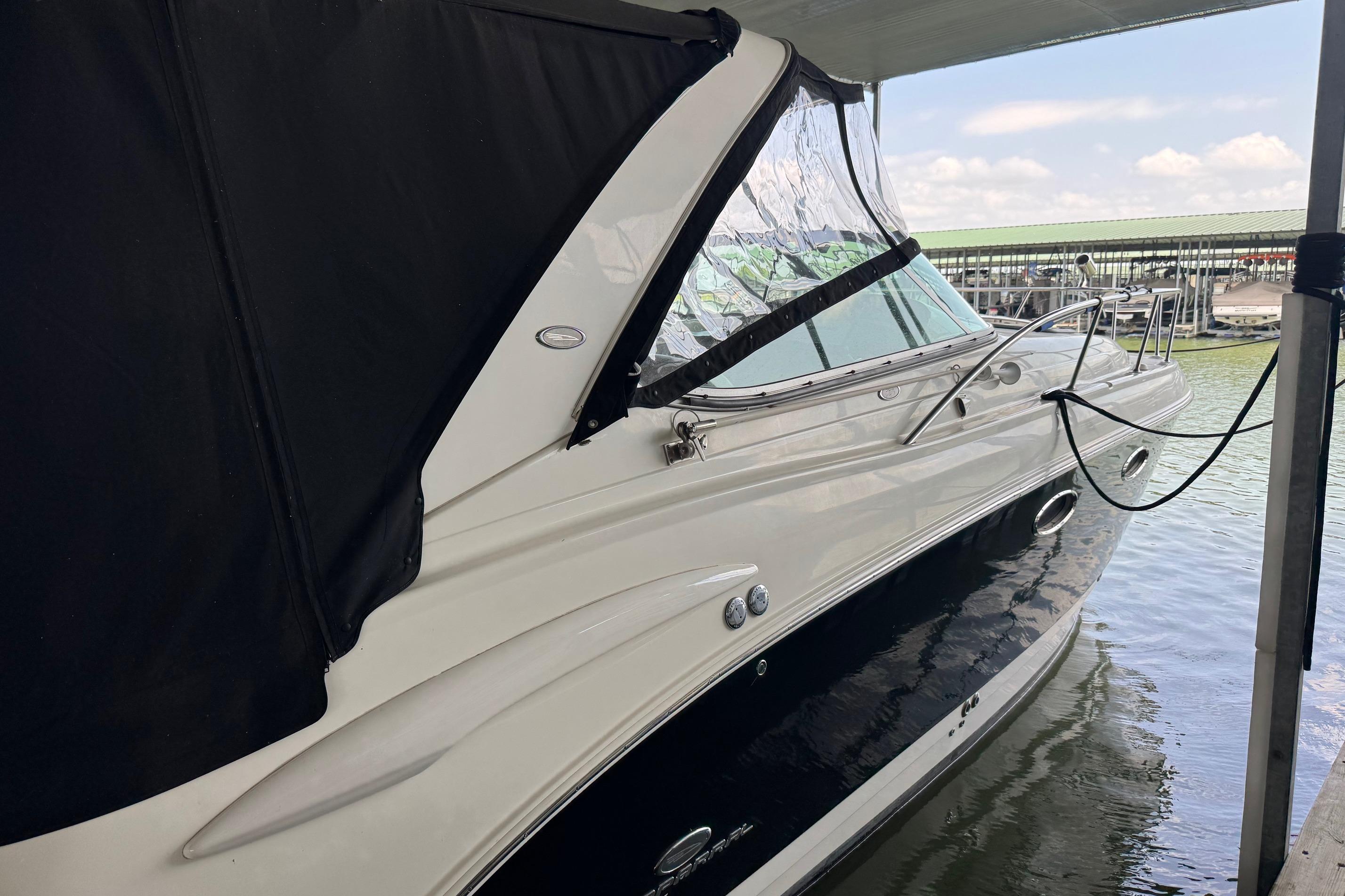2006 Chaparral 330 Signature boat docked, featuring sleek design and black canopy.