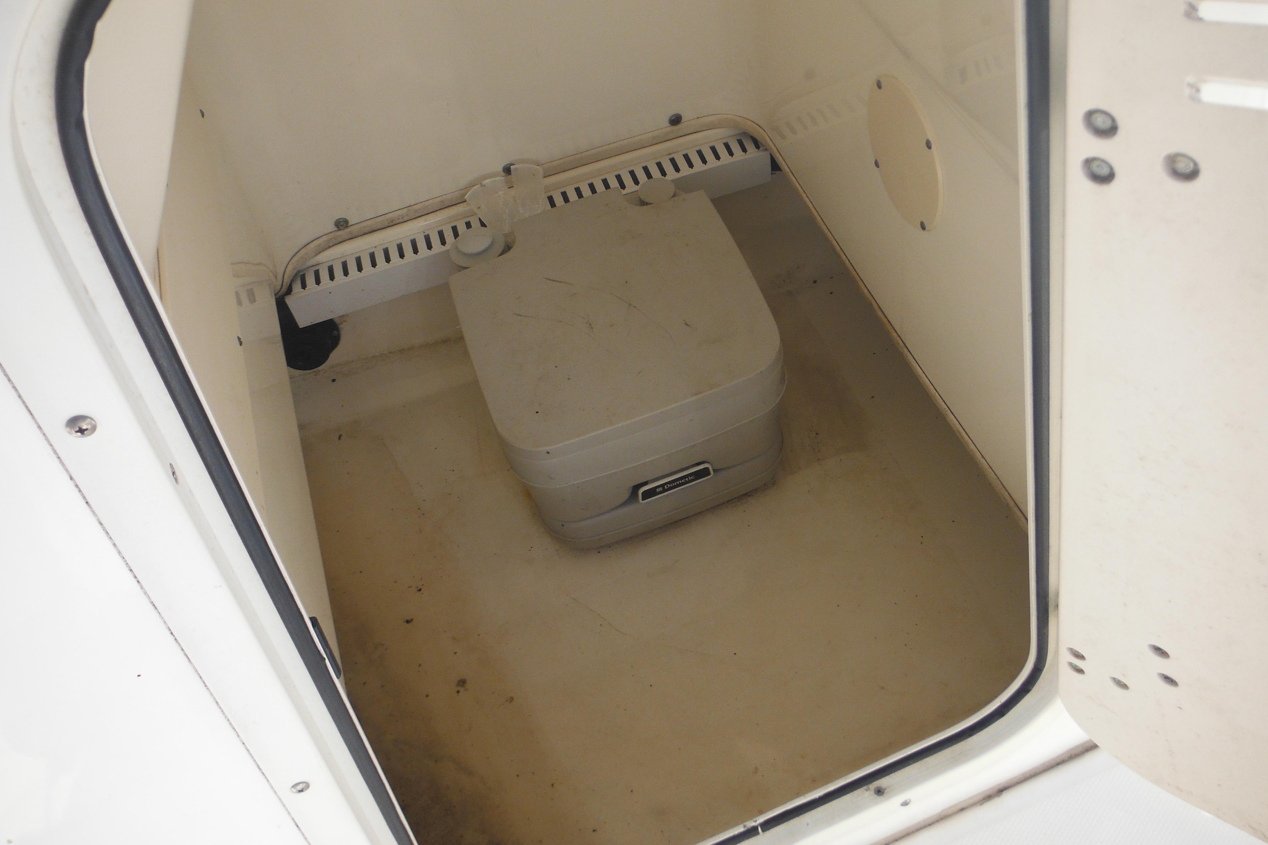 2009 Boston Whaler 200 Dauntless boat storage compartment with portable toilet.