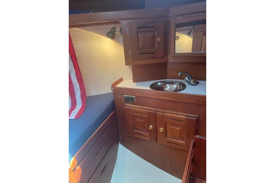 Interior of 2001 Tartan 3700 sailboat with wooden cabinetry and compact sink area.