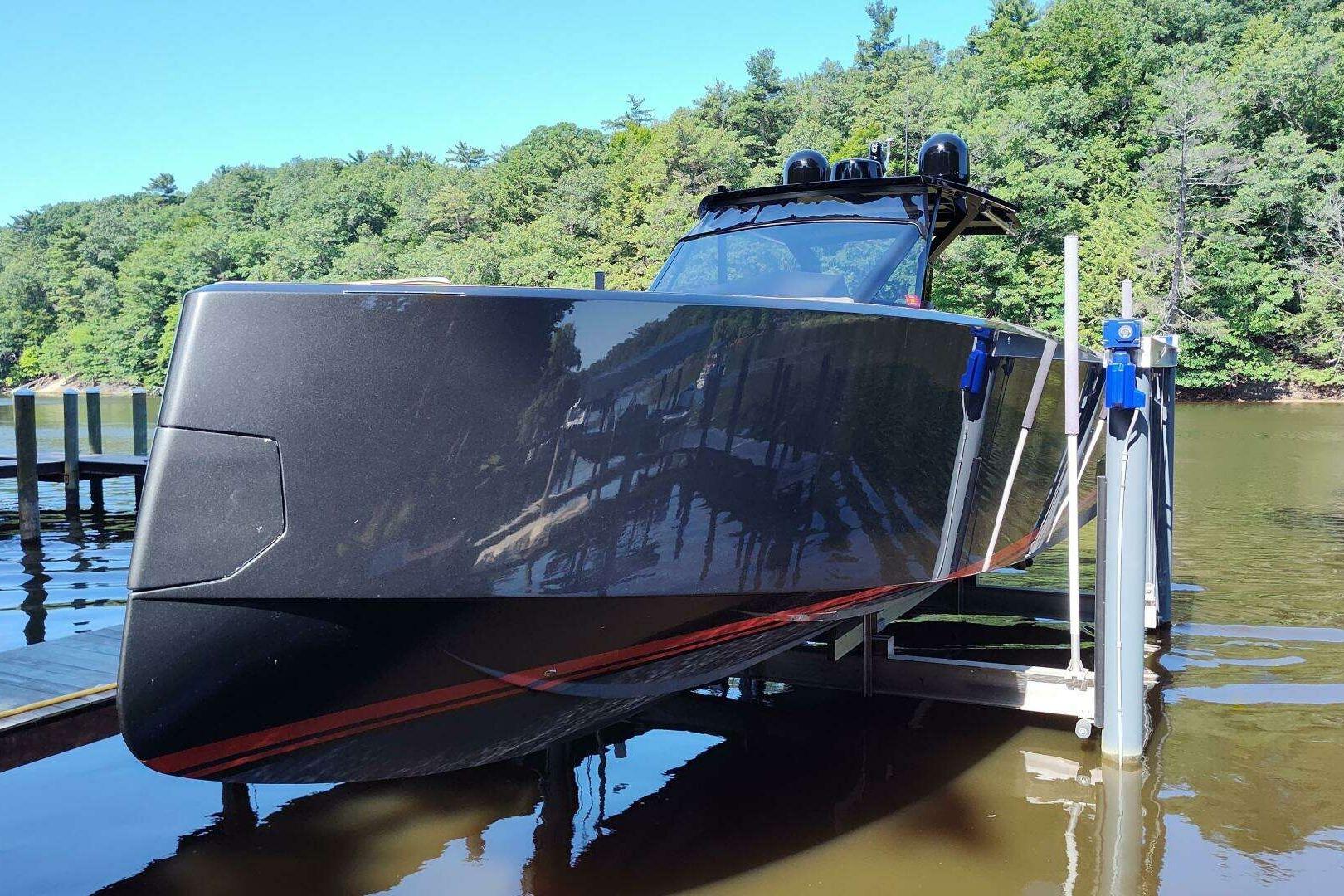 2023 Pardo Yachts P43 on lift, sleek design, docked by lush green forest.