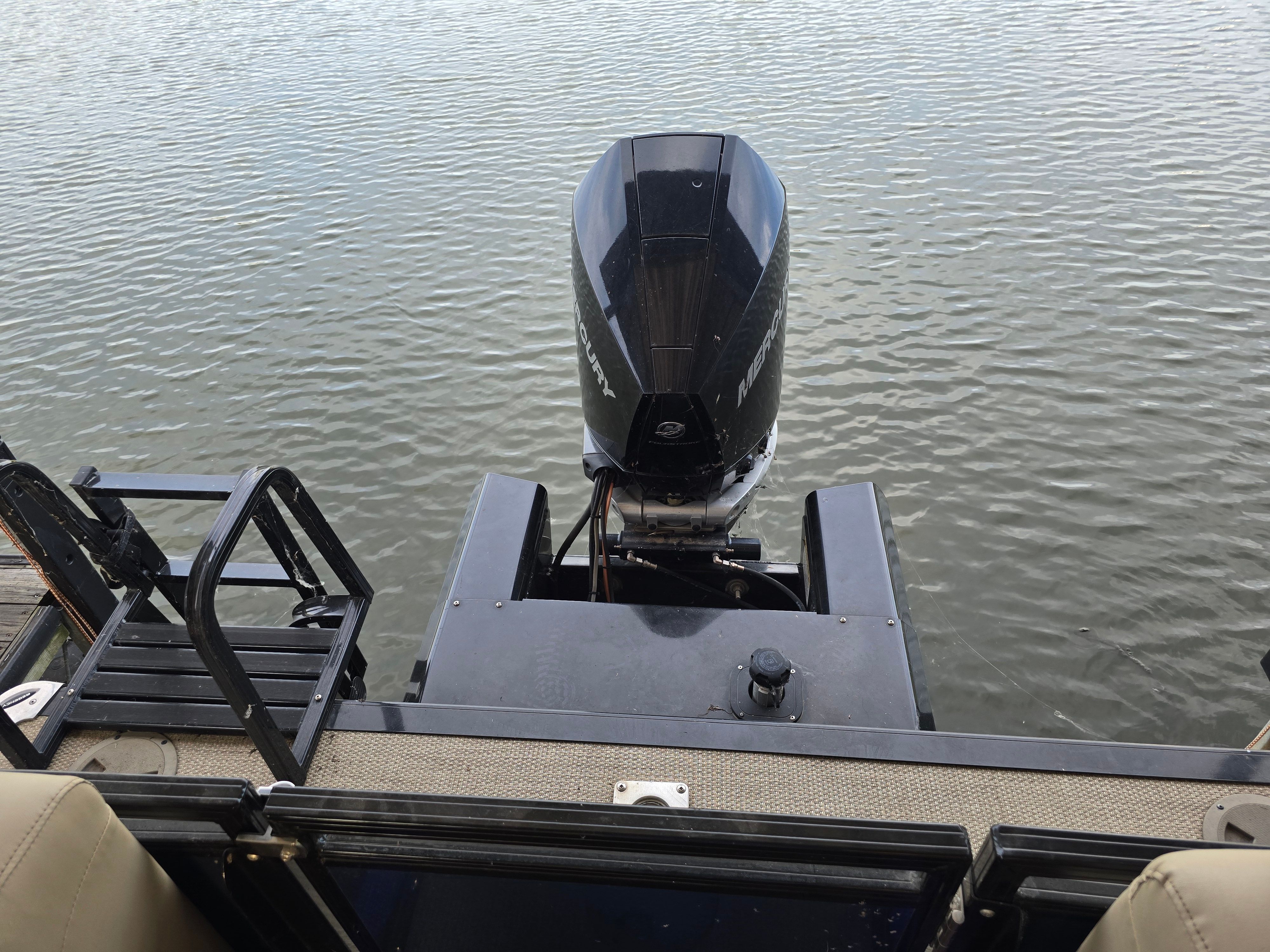 View from the stern of a Regency 230 LE3, showing the outboard motor over calm water.