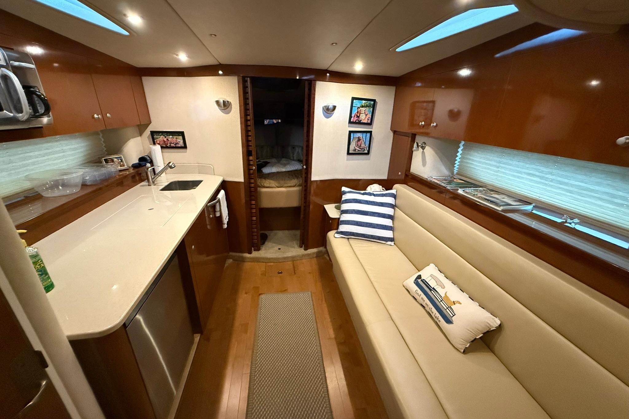 Interior of 2009 Sea Ray 350 Sundancer yacht with modern kitchen and cozy seating area.
