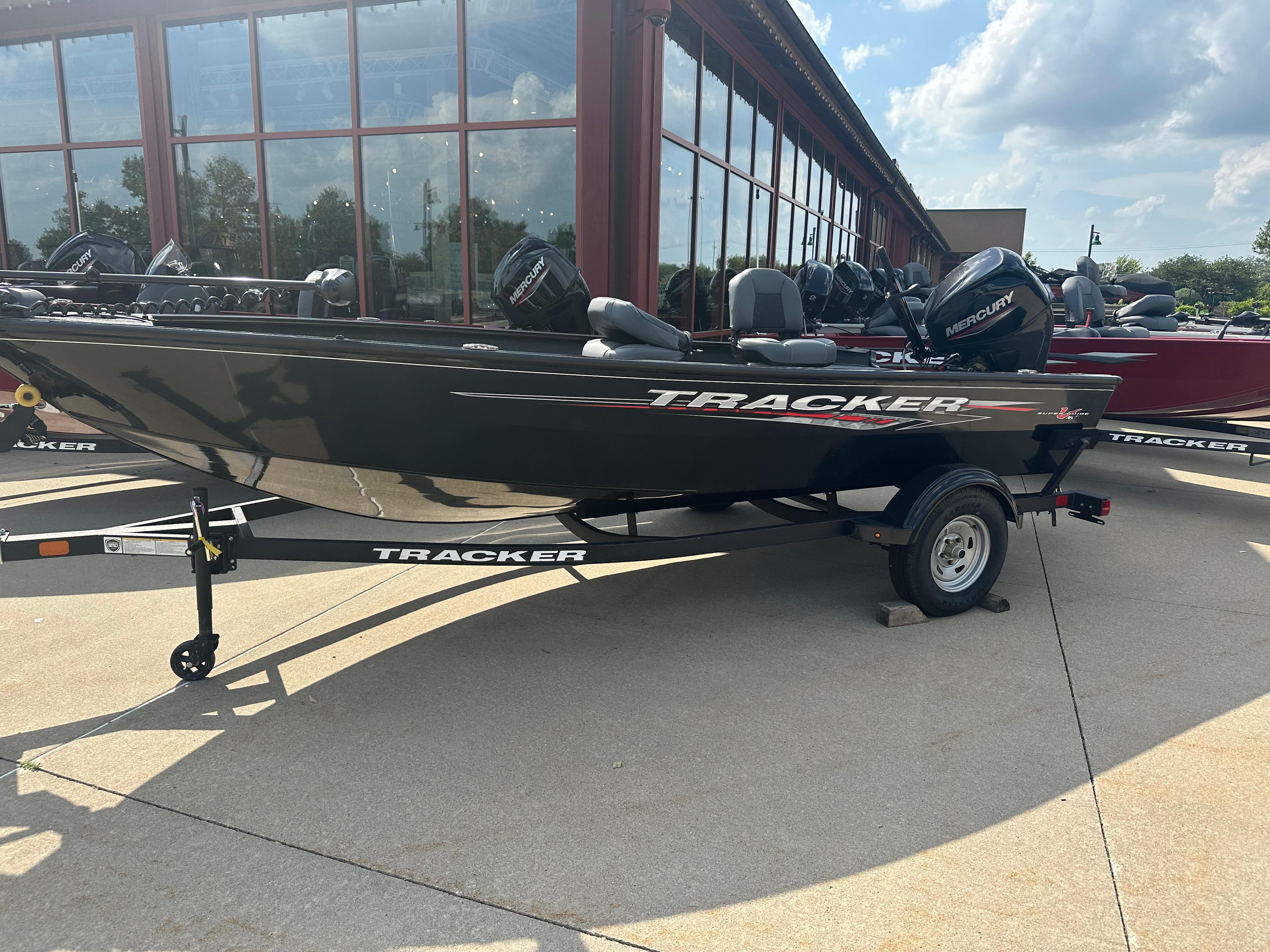 2025 Tracker Super Guide V-16 T boat on trailer, parked outdoors.
