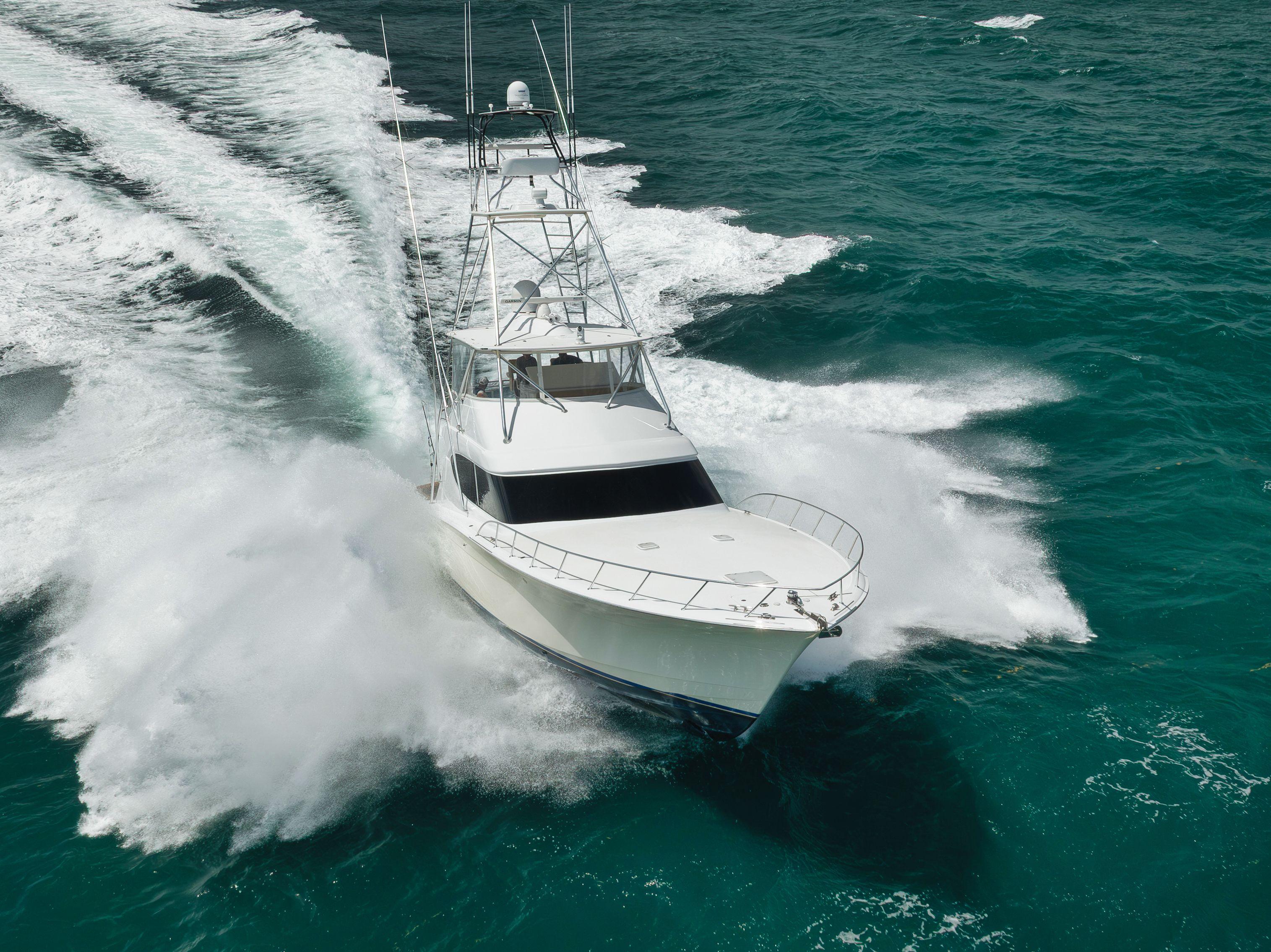 Hatteras 60GT 2009 yacht cruising swiftly on turquoise ocean waters.
