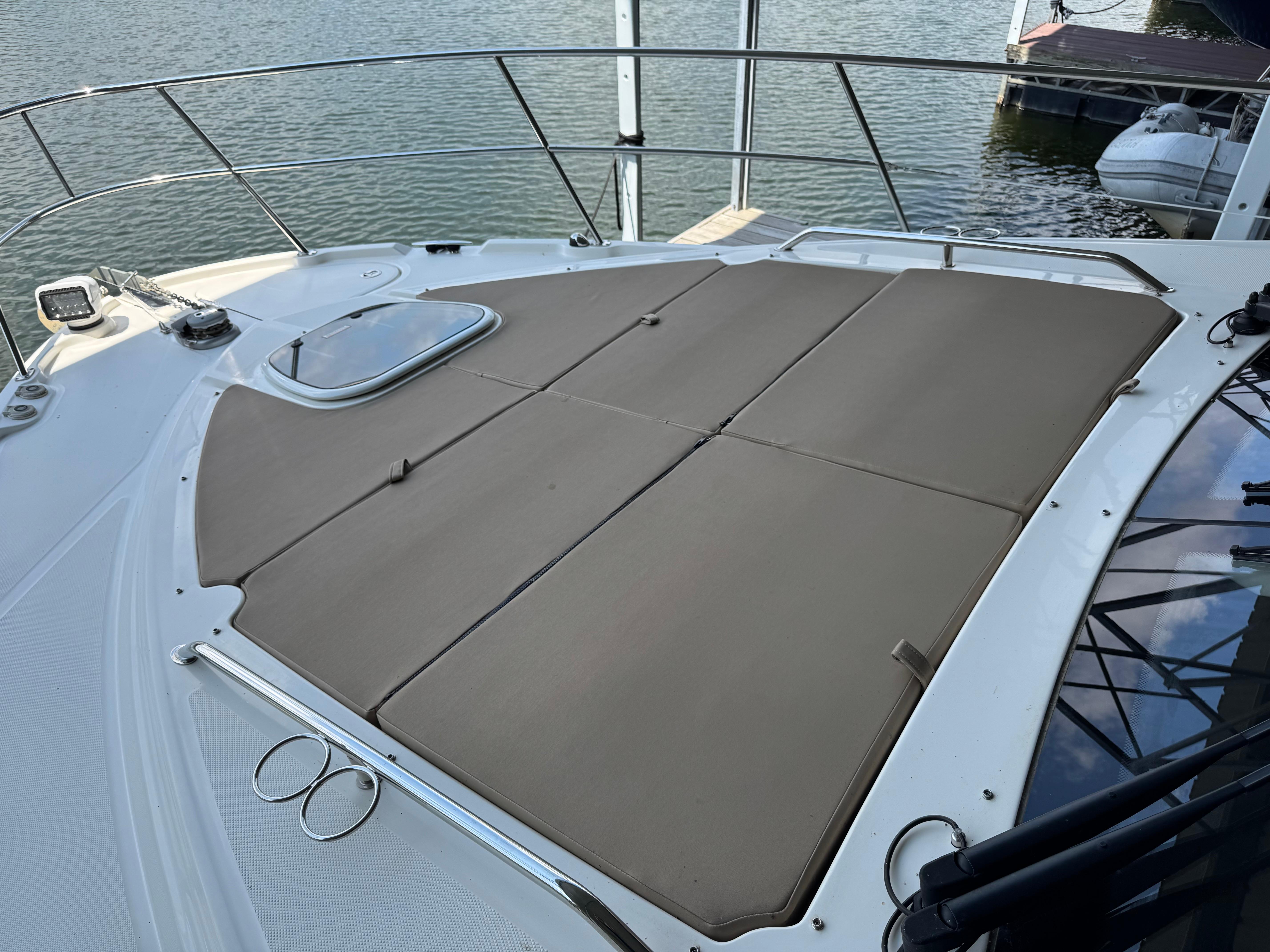 2017 Sea Ray Sundancer 400 boat with sunpad on deck, docked by the water.