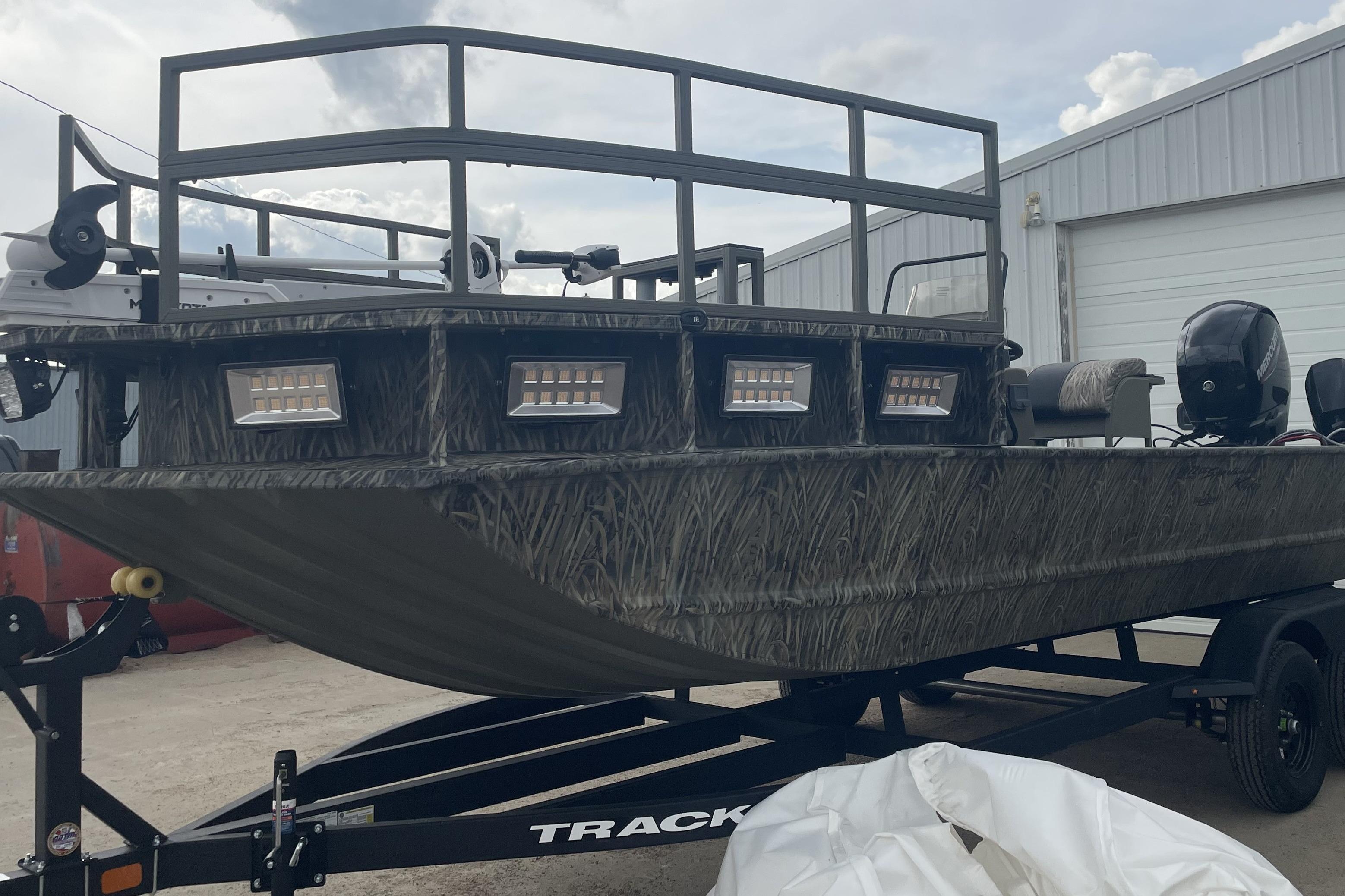 2026 Tracker Grizzly 2072 CC Sportsman Kicker boat on trailer, featuring camouflage design.