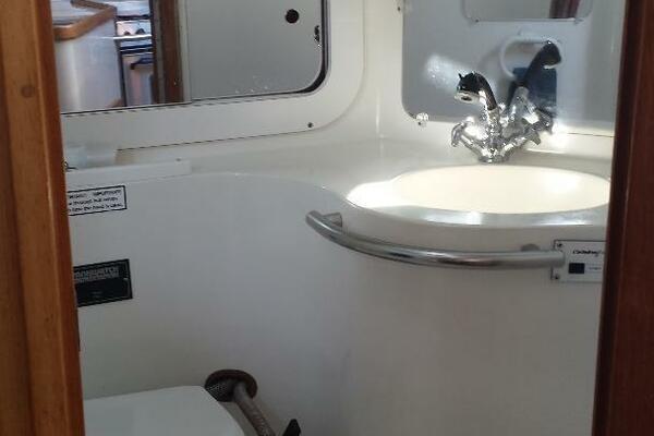 Bathroom interior of a 1994 Catalina 320 yacht, featuring a sink and mirror.