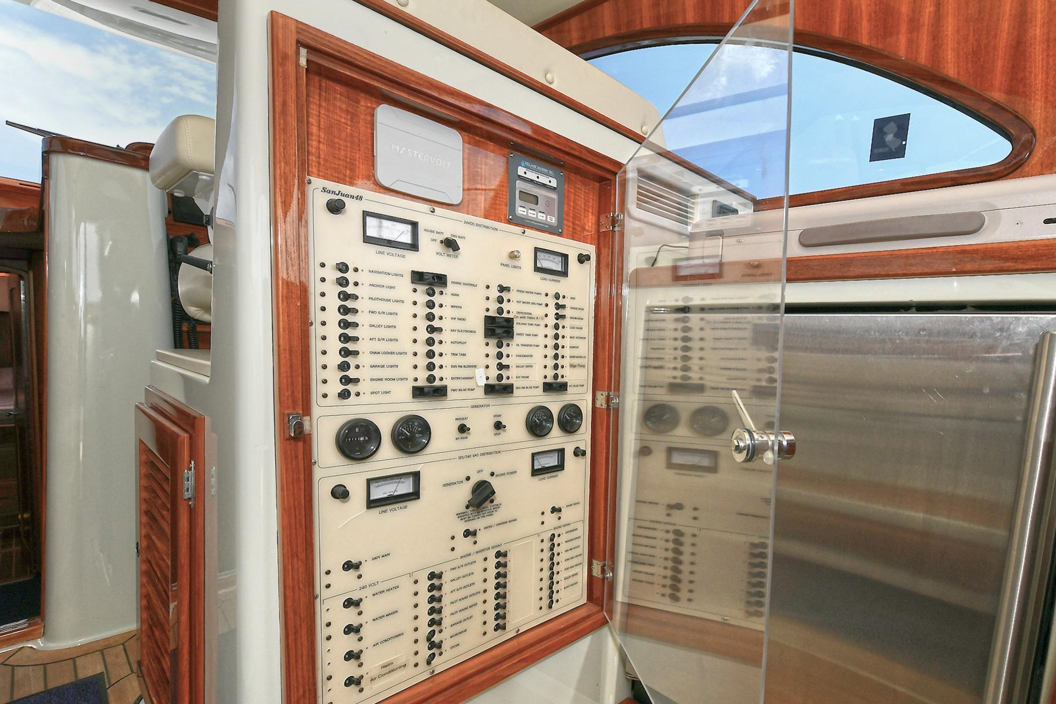 Electrical control panel inside a 2005 San Juan Downeast Express boat, featuring wood accents.