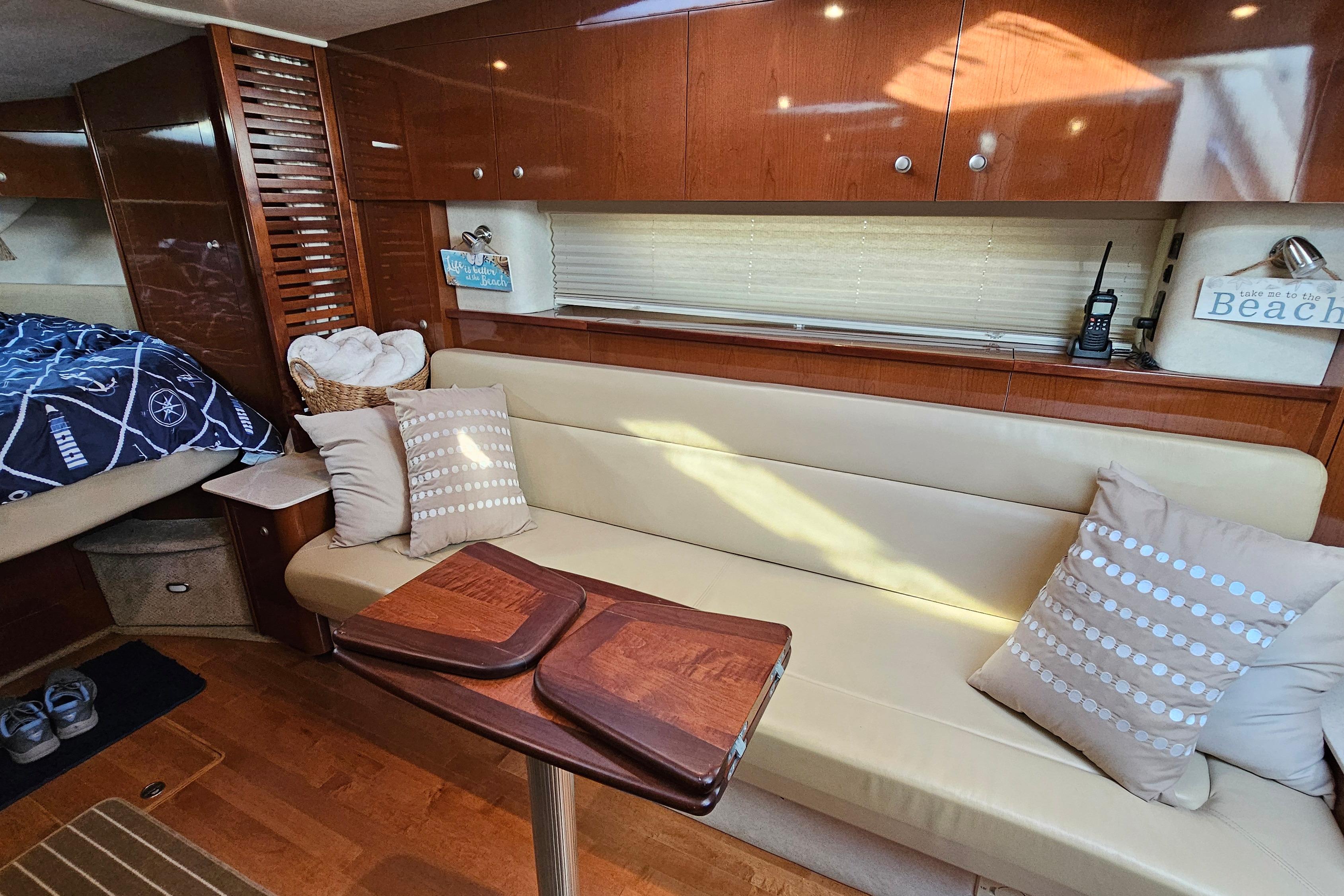 Interior of 2008 Sea Ray Sundancer 350 yacht with cozy seating and wooden accents.