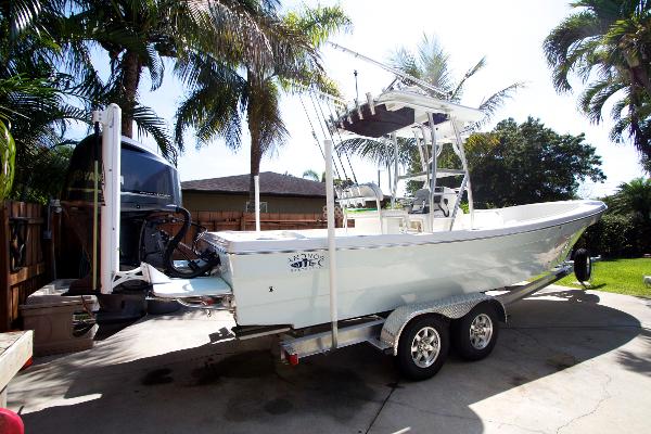 A 2011 Andros 26 Tarpon boat on a trailer, surrounded by palm trees.