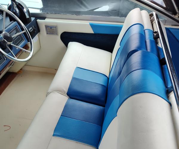 1988 Sea Ray 268 DA interior with blue and white seating, steering wheel visible.
