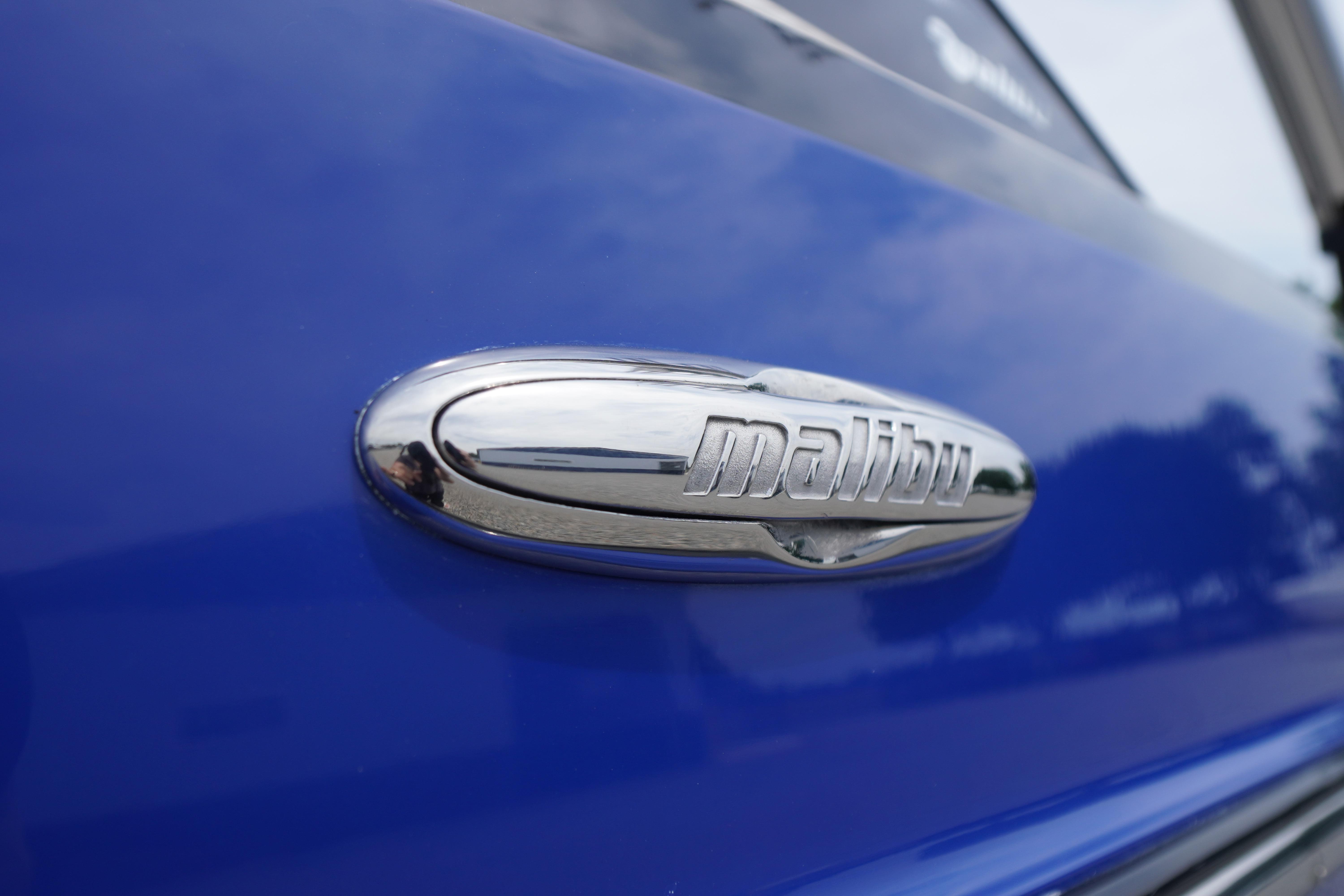Close-up of 2011 Malibu Wakesetter 21 VLX logo on blue surface.