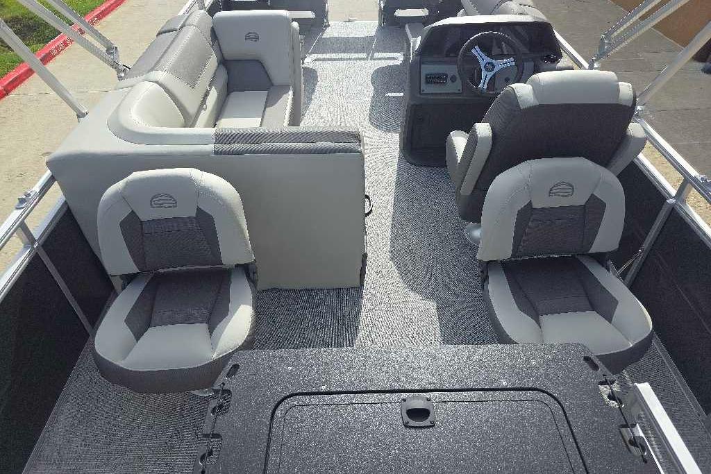 2026 Sun Tracker Fishin' Barge 20 DLX interior with gray seating and steering console.