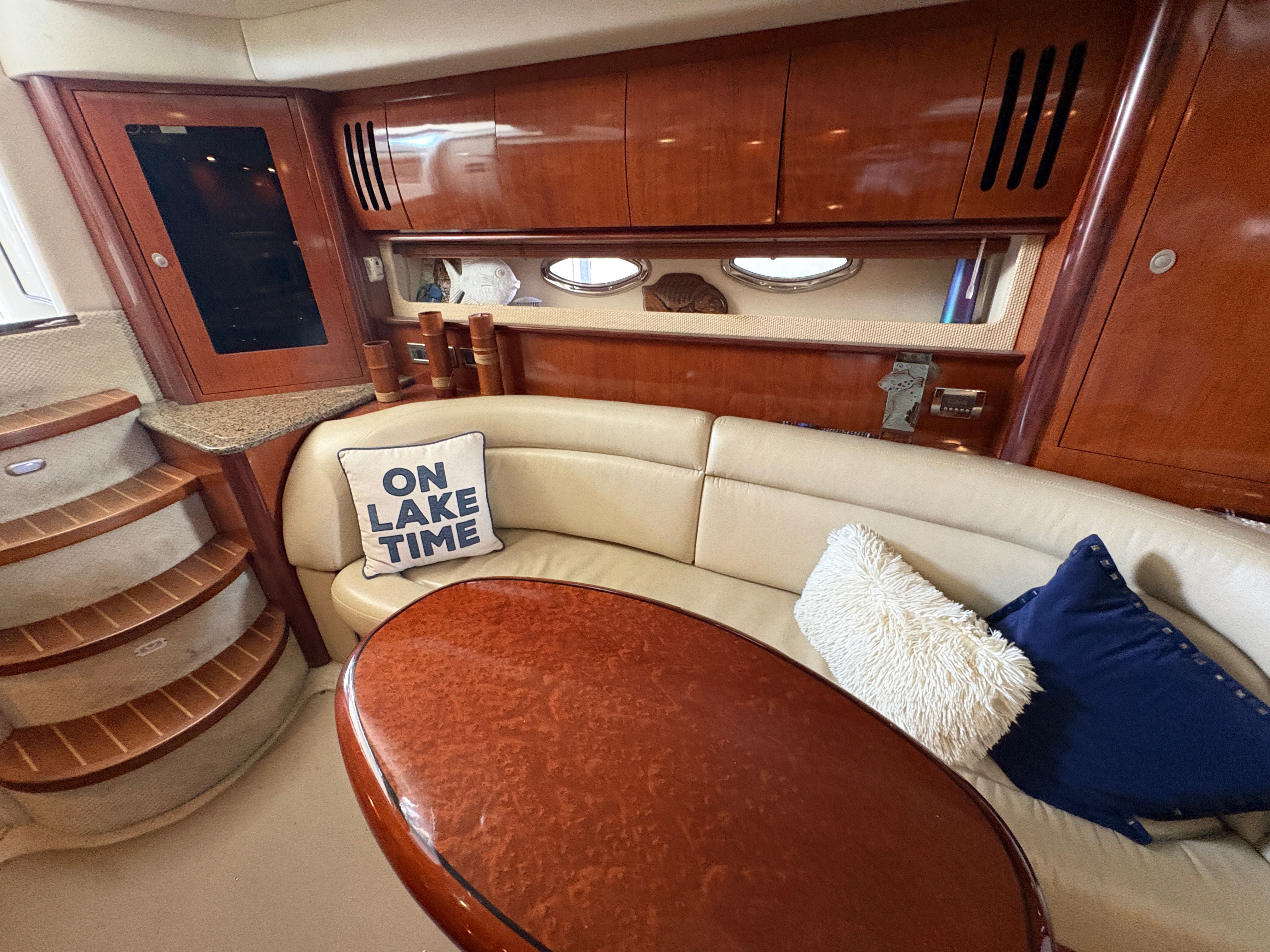 Interior of a 2005 Sea Ray 420 Sundancer yacht with cushions and wooden furnishings.