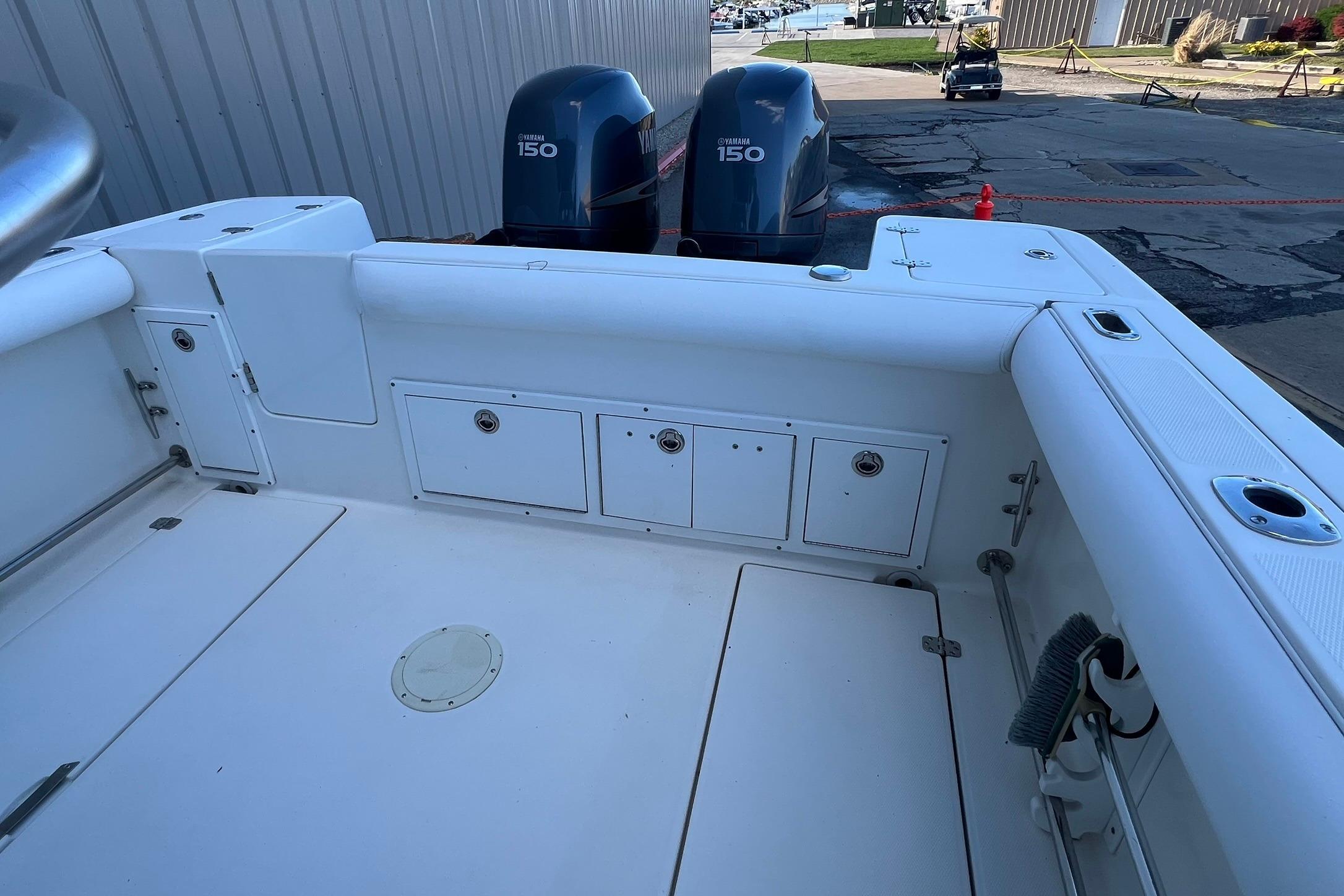 2006 Edgewater 245CC boat deck with twin Yamaha 150 engines, dockside view.