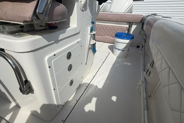 2014 Edgewater 318CC boat interior with seating, storage compartments, and a bucket.