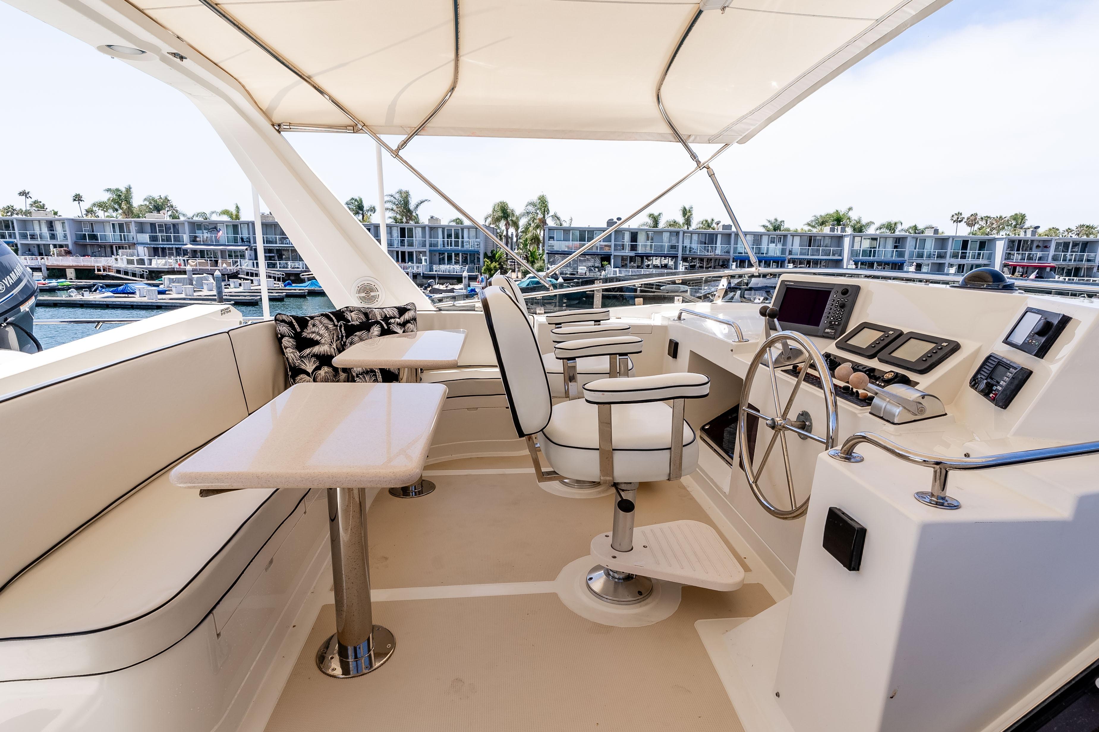 Luxurious 2005 Offshore Yachts 54 Pilothouse helm with seating and navigation equipment.
