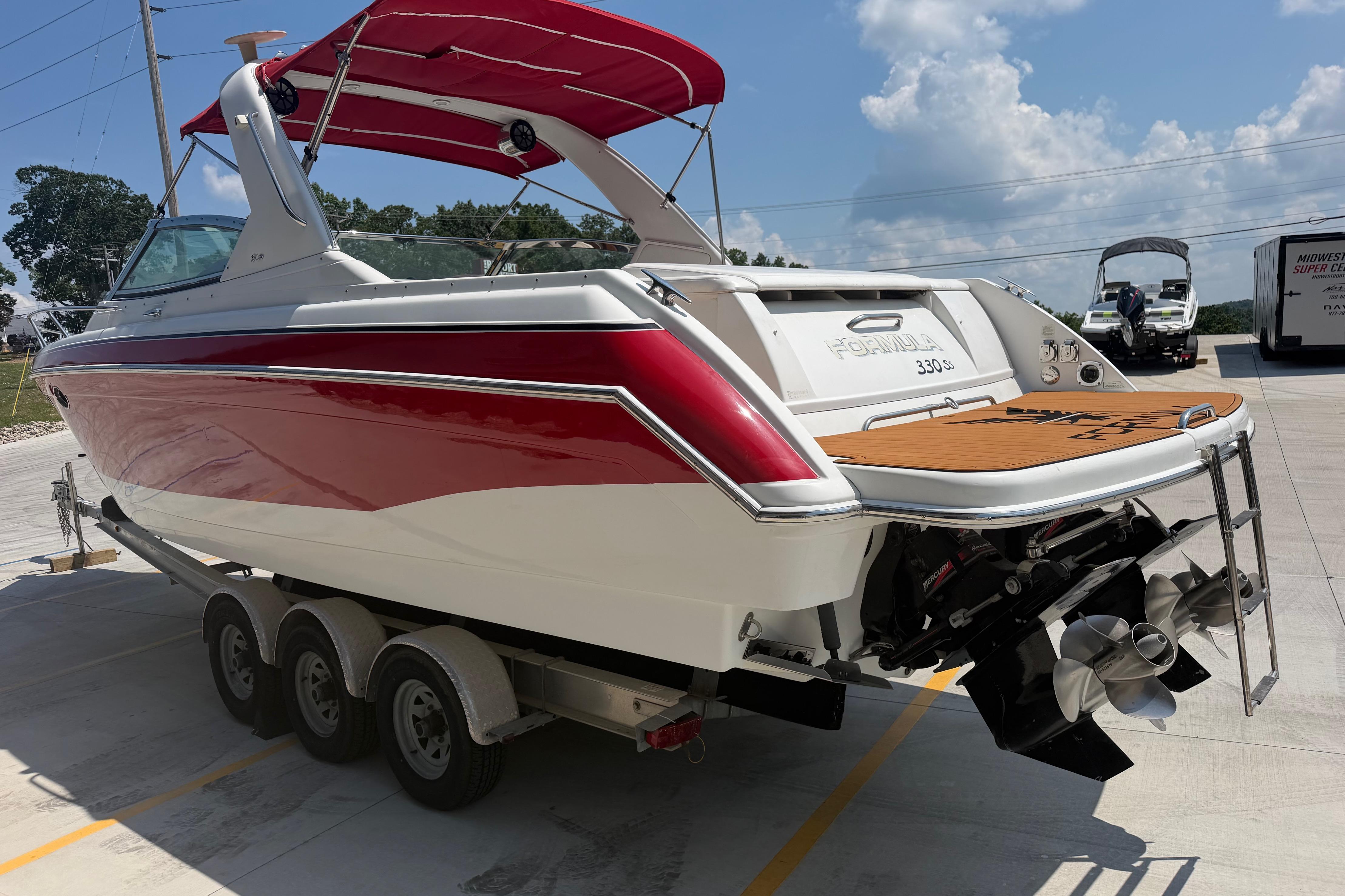 2006 Formula 330 Sun Sport boat with red and white exterior on a trailer.
