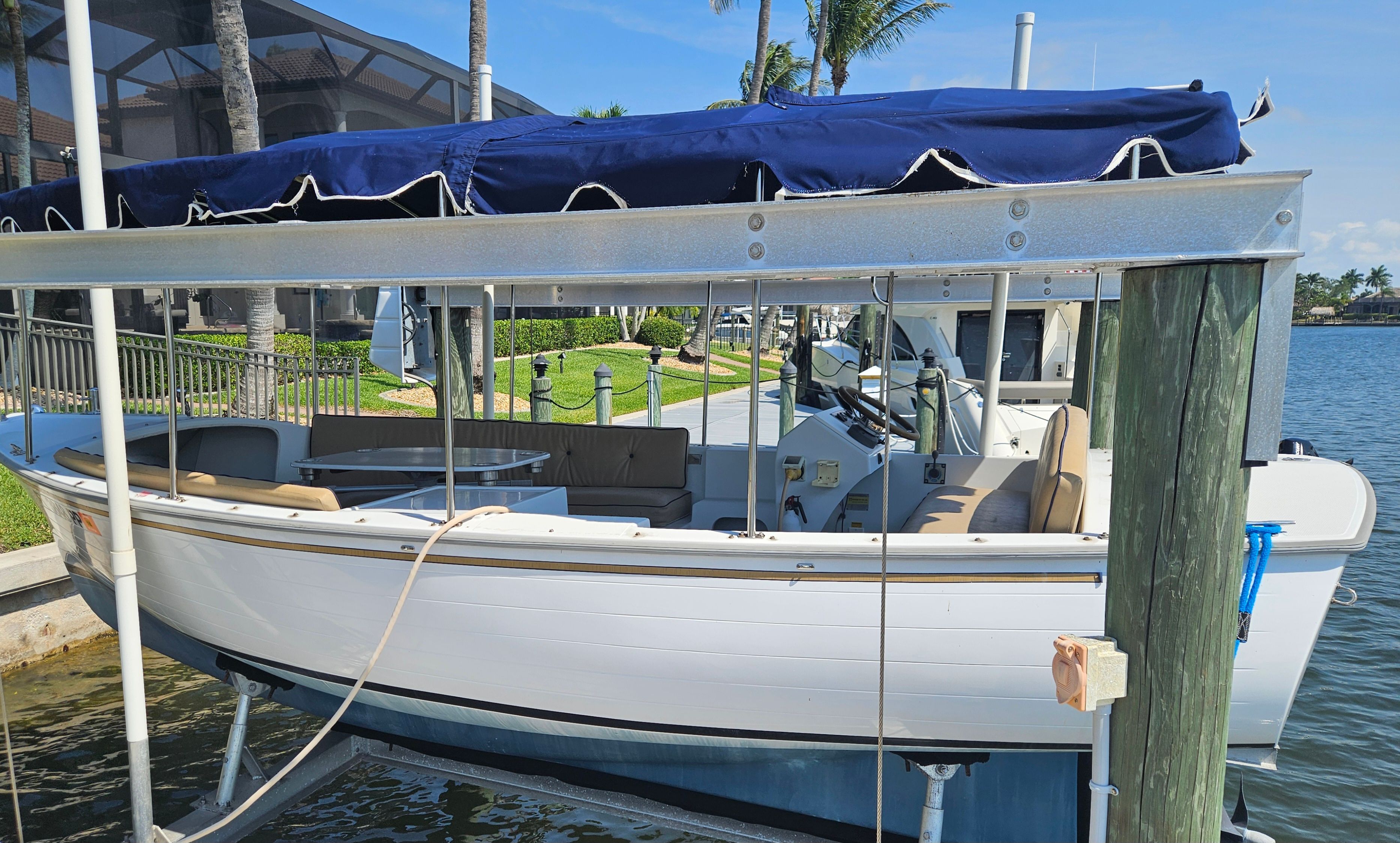 2012 Duffy Snug Harbor 18 boat docked with blue canopy.