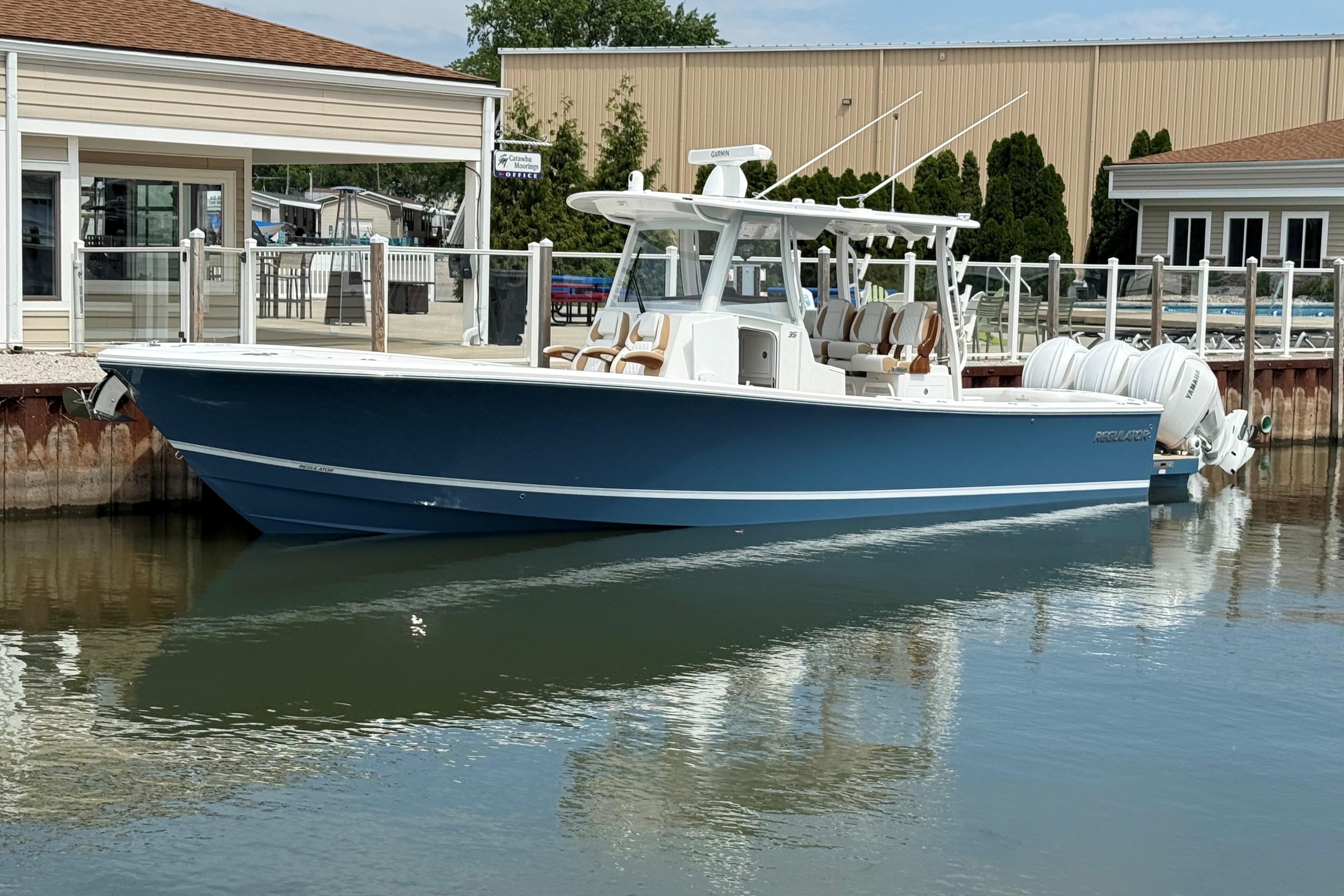 2027 Regulator 35 boat docked, featuring sleek blue design and powerful engines.