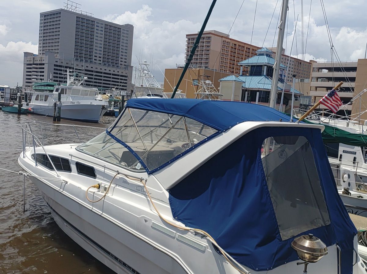 Bayliner Ciera 2000 docked with blue cover and American flag.