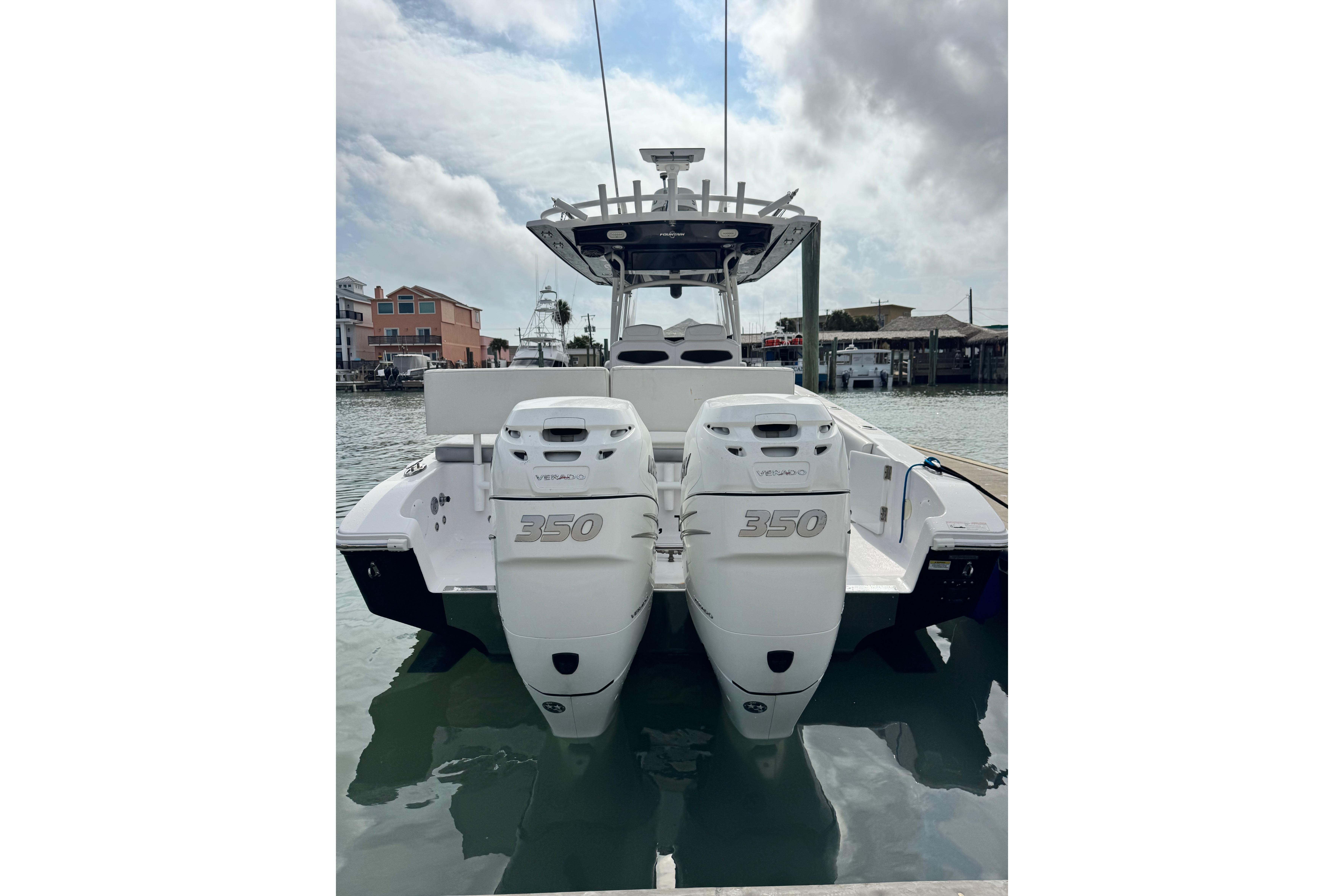 2018 Fountain 34 Center Console boat with twin 350 engines docked in marina.