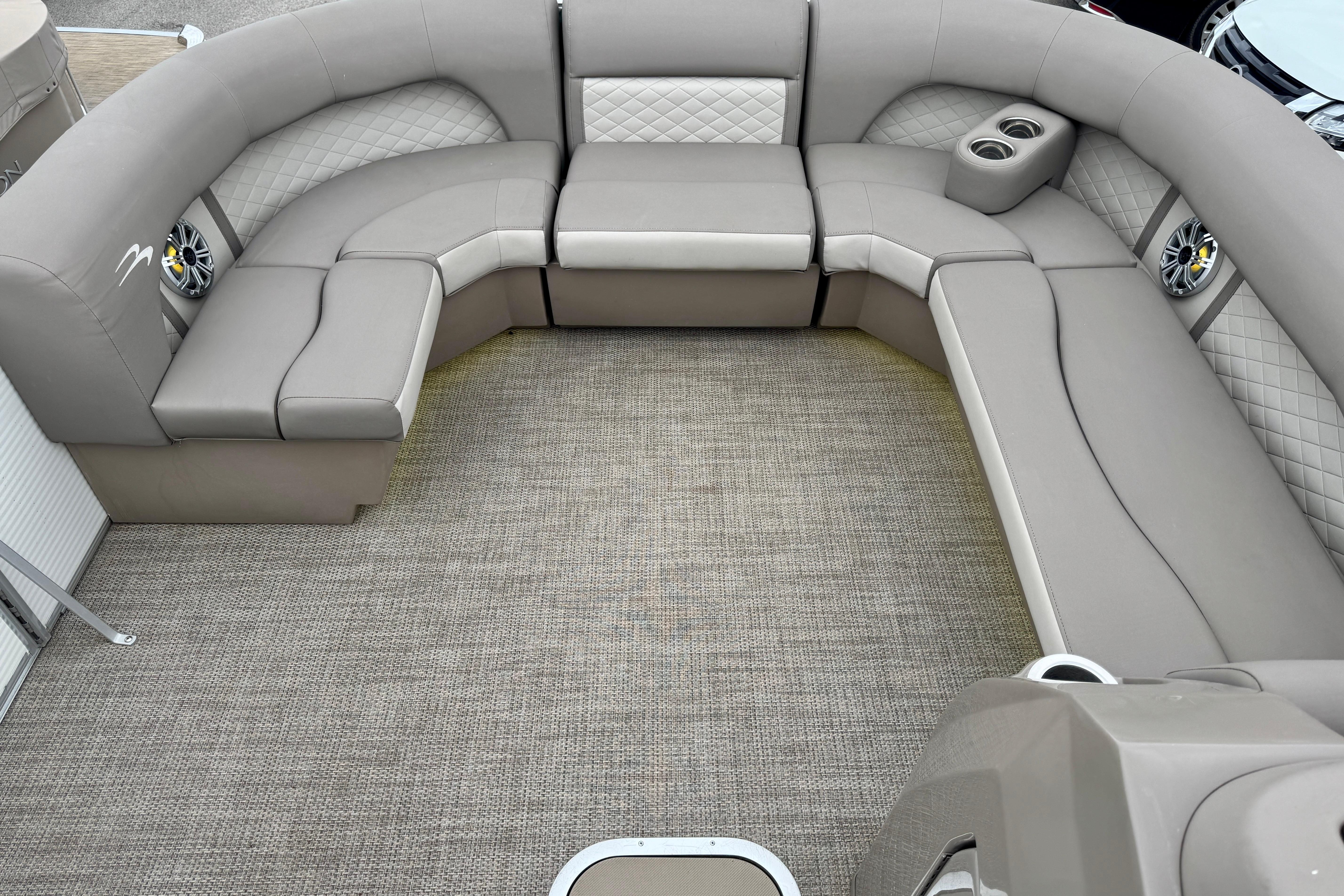 Luxurious seating area on 2019 Bennington SX 22 SSBXP pontoon boat with speakers and cup holders.