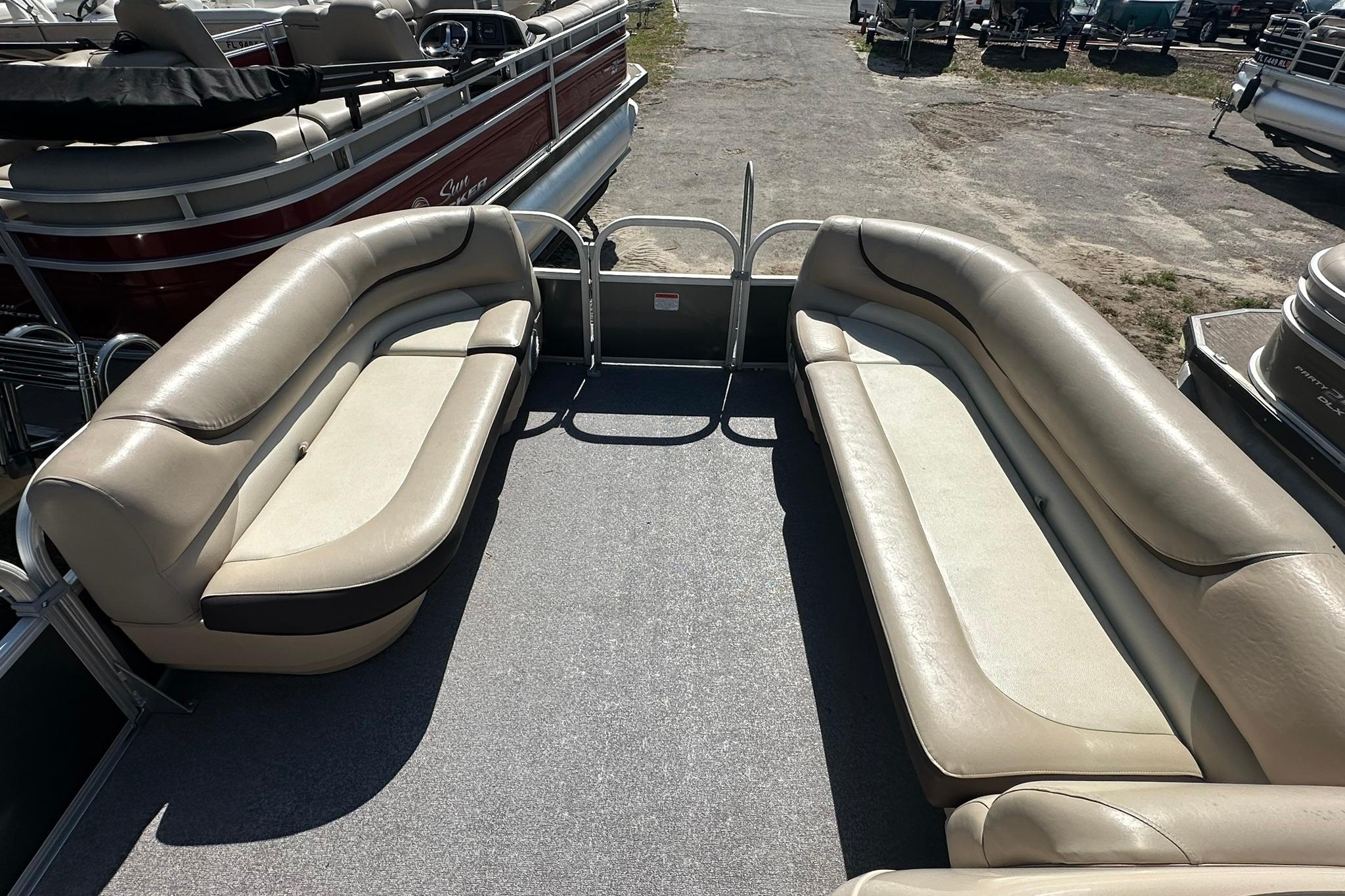 2016 SUNTRACKER Party Barge 20 with beige seating, docked in a marina.