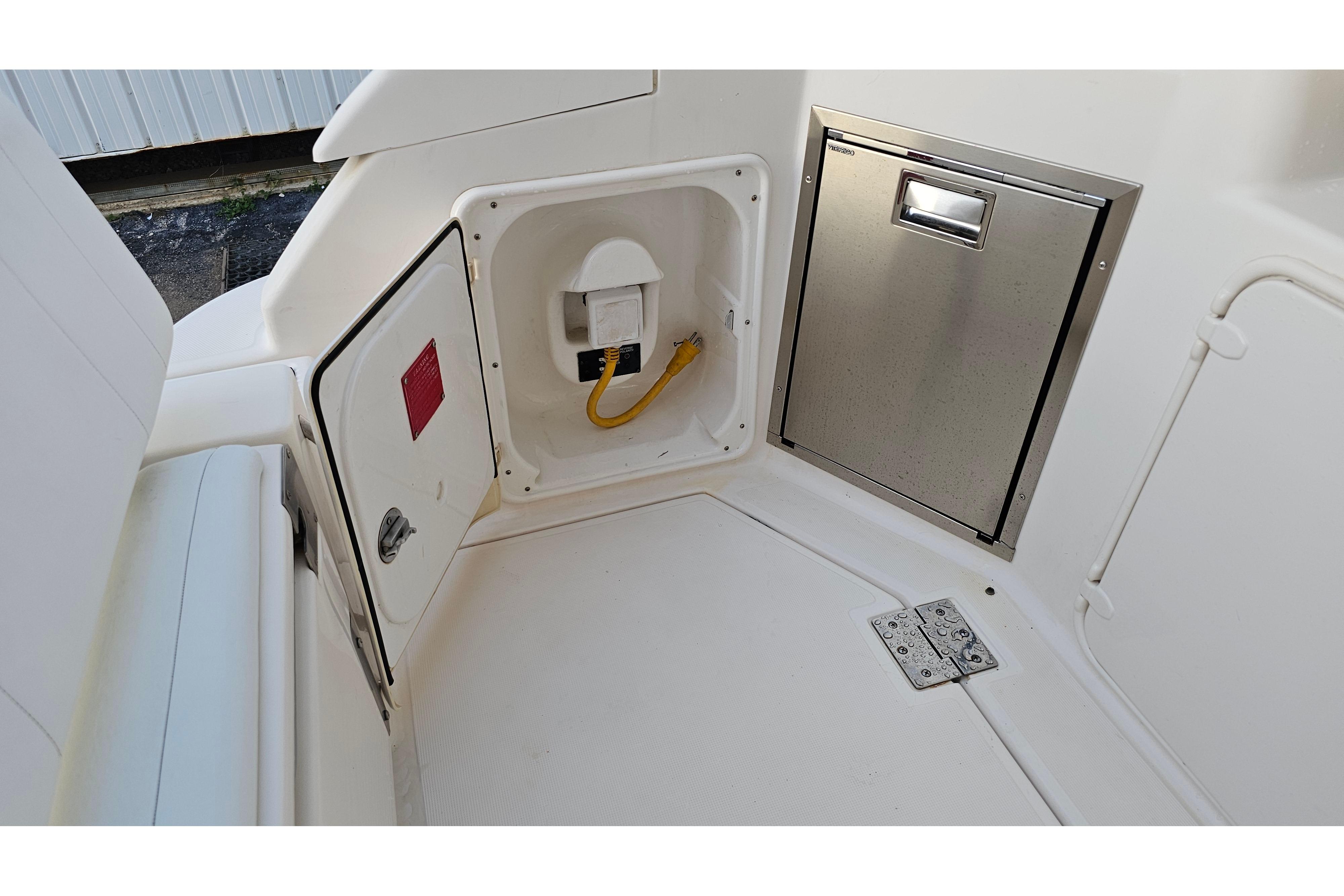 2005 Regal 3060 Window Express boat interior with storage compartments and electrical outlet.