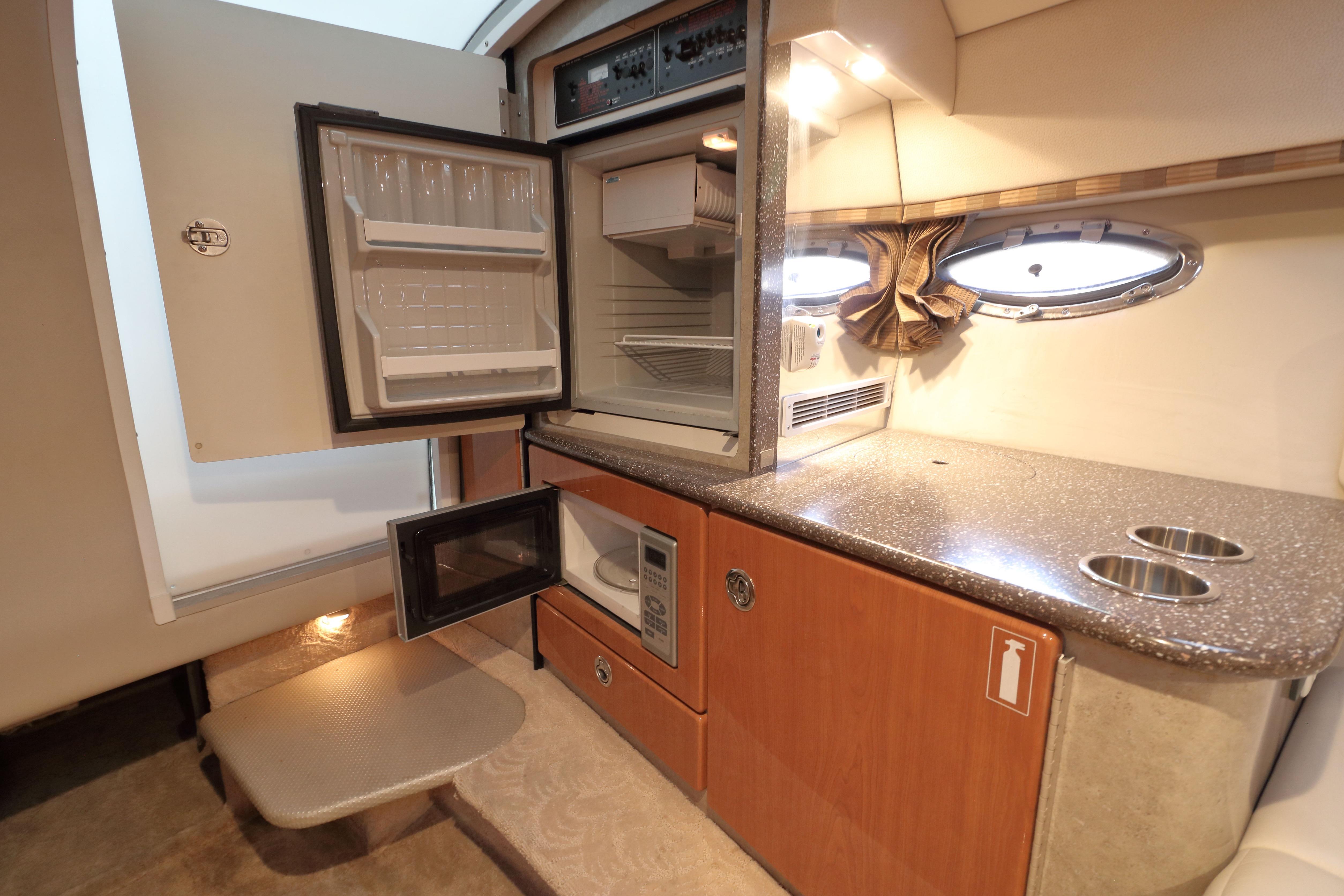 2006 Formula 330 Sun Sport interior kitchen with fridge, microwave, and countertop.