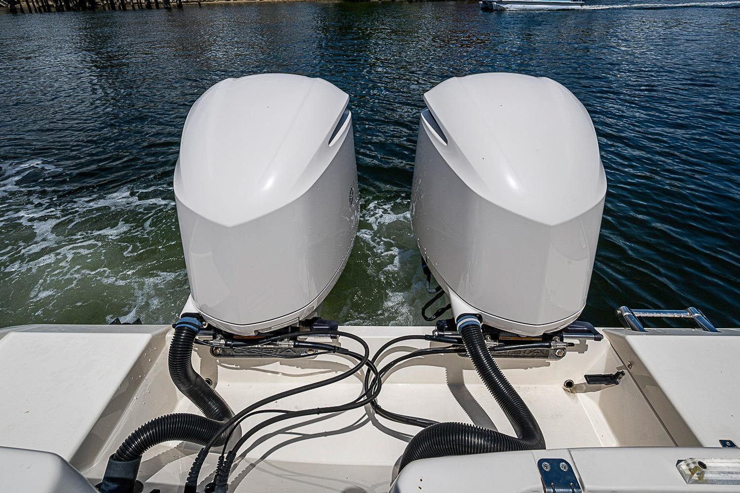 2019 Cobia 320 Center Console with dual outboard engines on water.