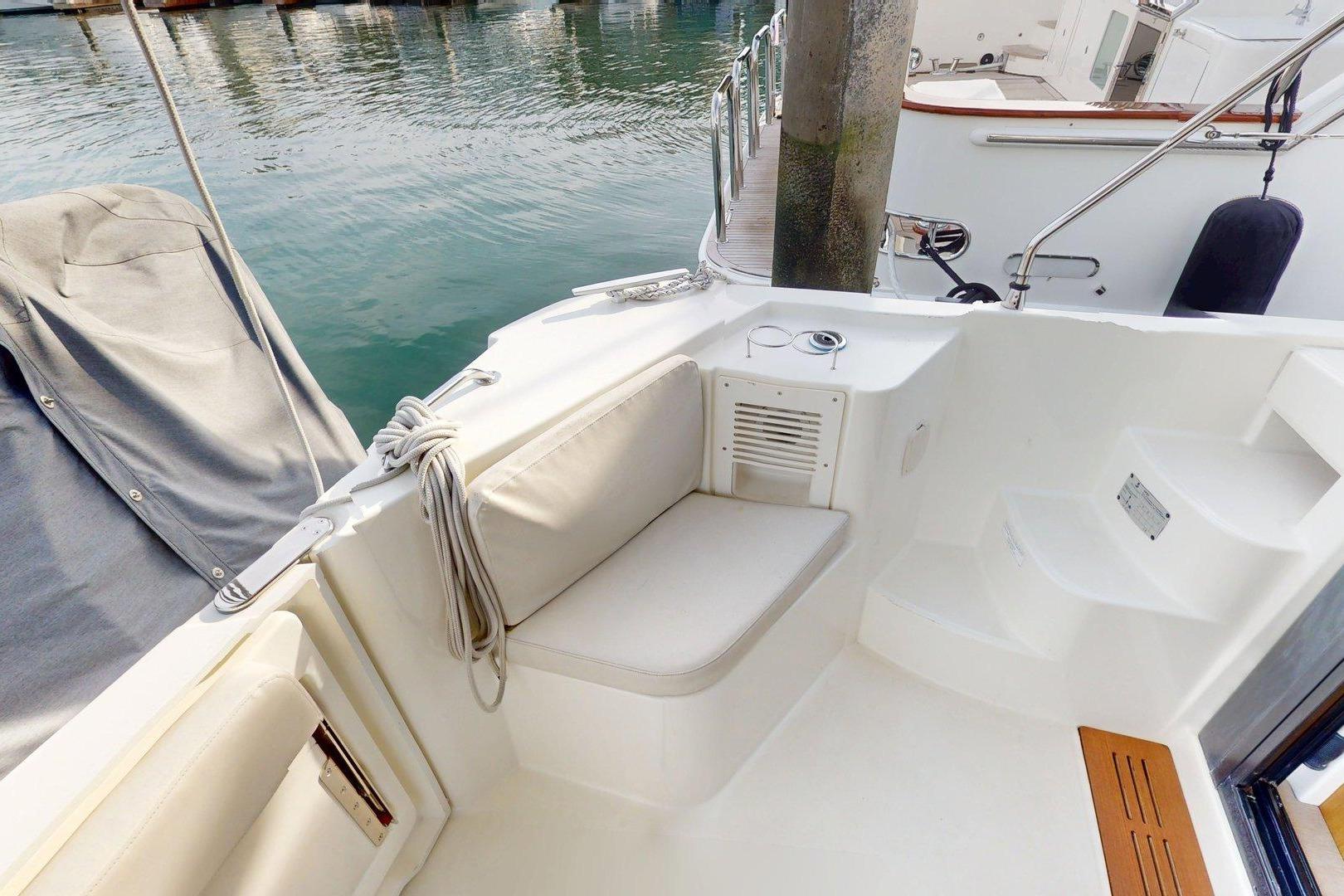 2021 Beneteau Swift Trawler 35 cockpit with seating, steps, and dock view.
