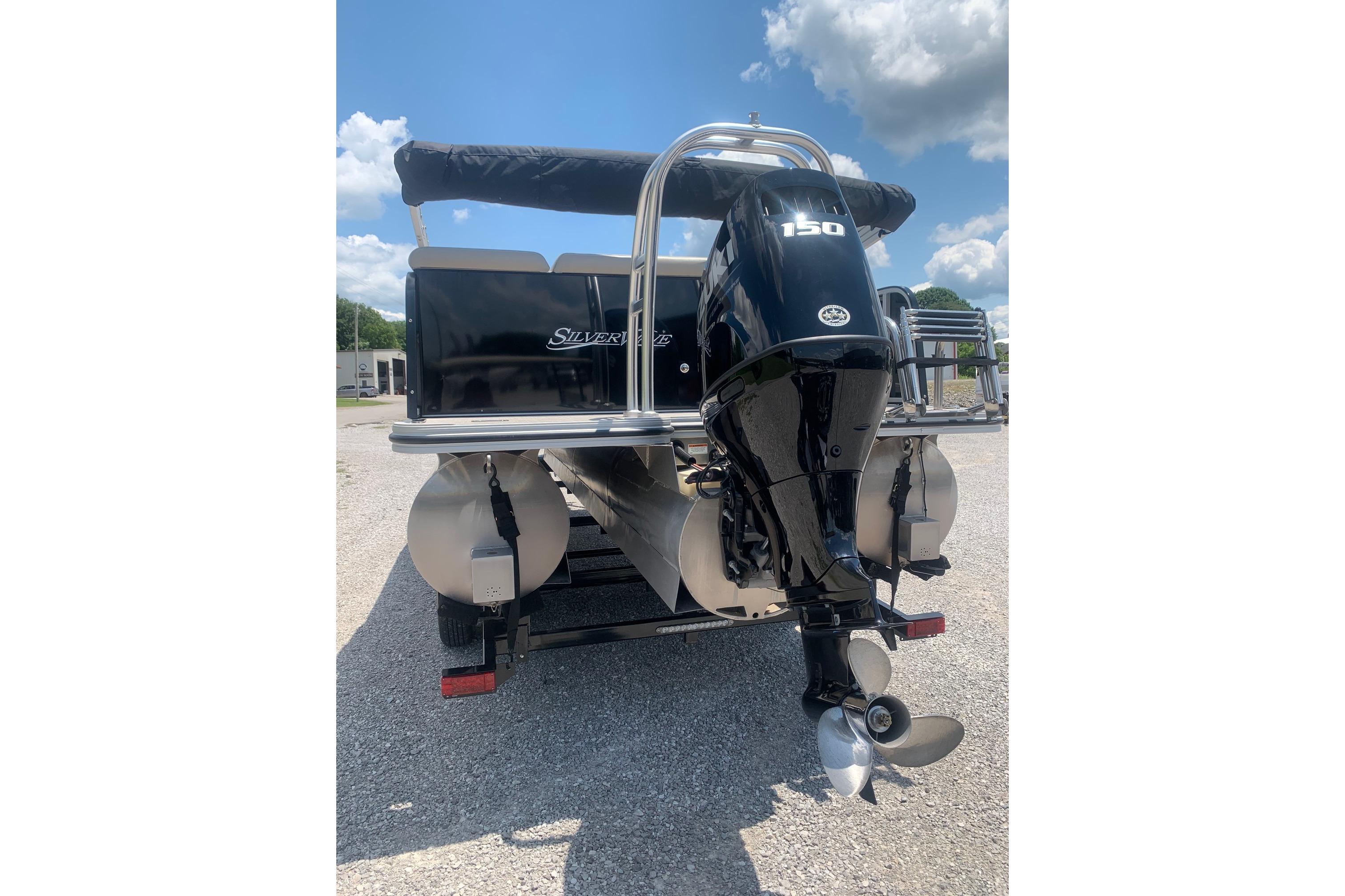 2023 Silver Wave 2410 SW3 CLS pontoon boat with powerful outboard motor, parked outdoors.