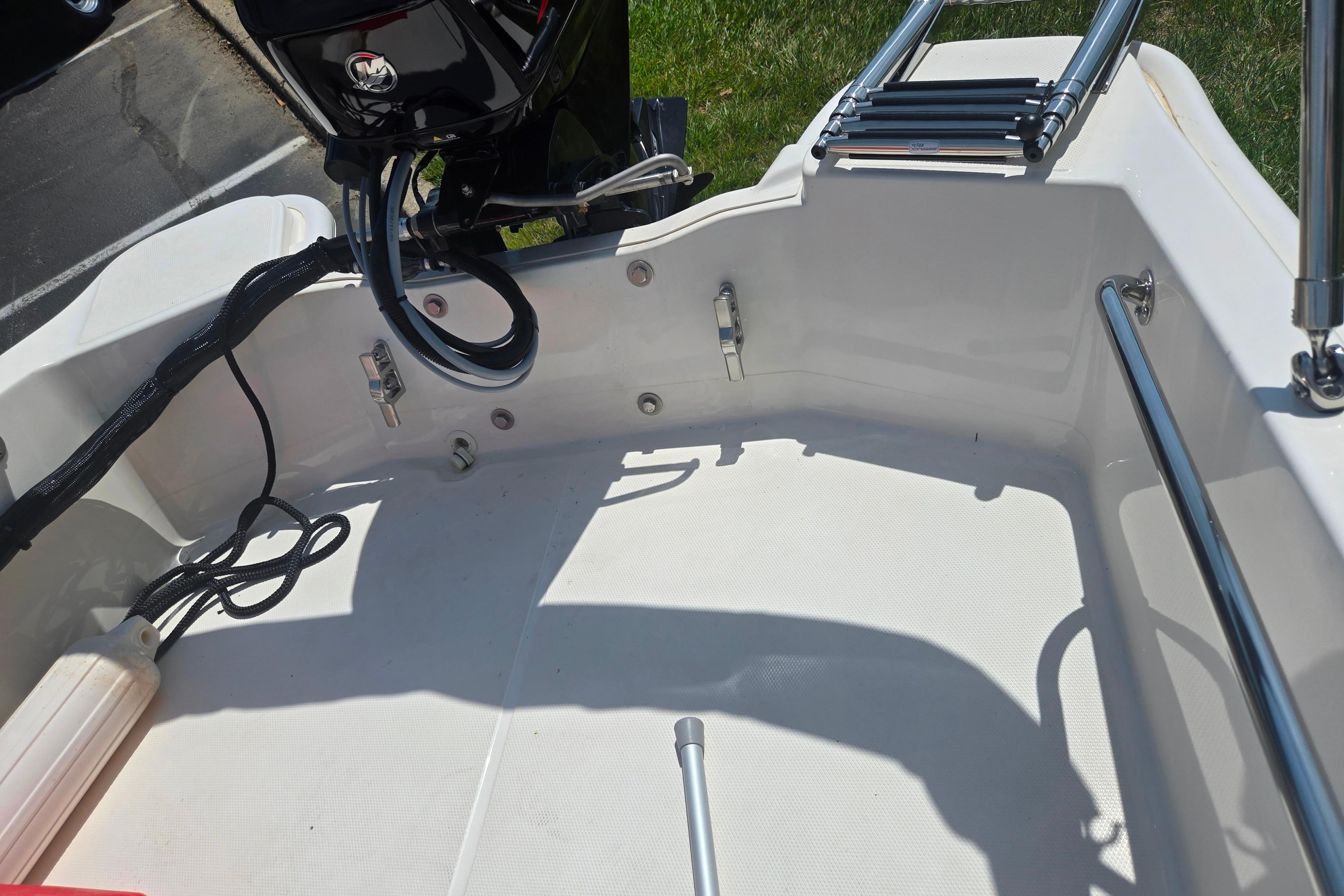 2025 Boston Whaler 130 Super Sport boat interior with motor and ladder.