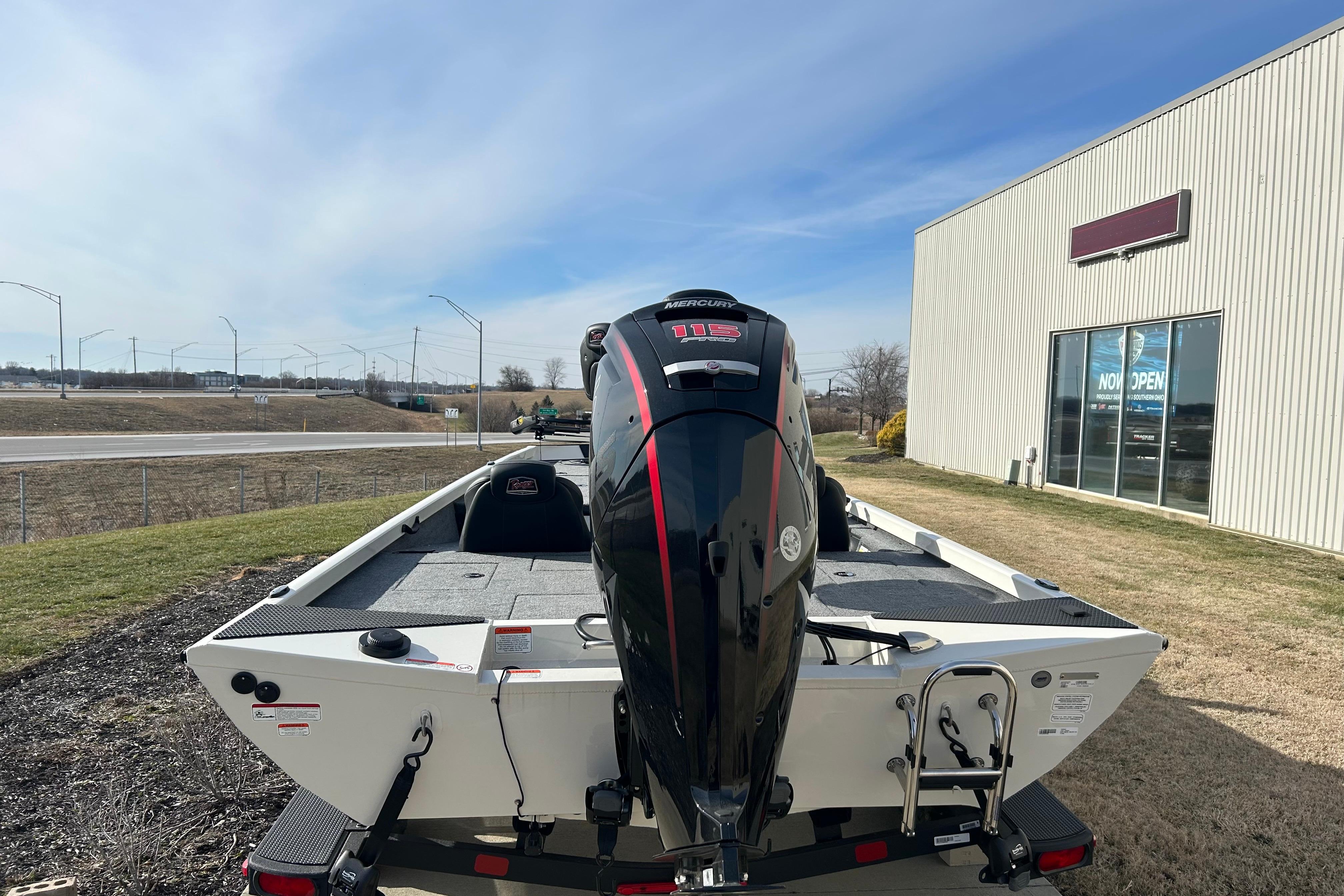 2026 Ranger RT188 boat with Mercury engine, parked outside a building on a sunny day.