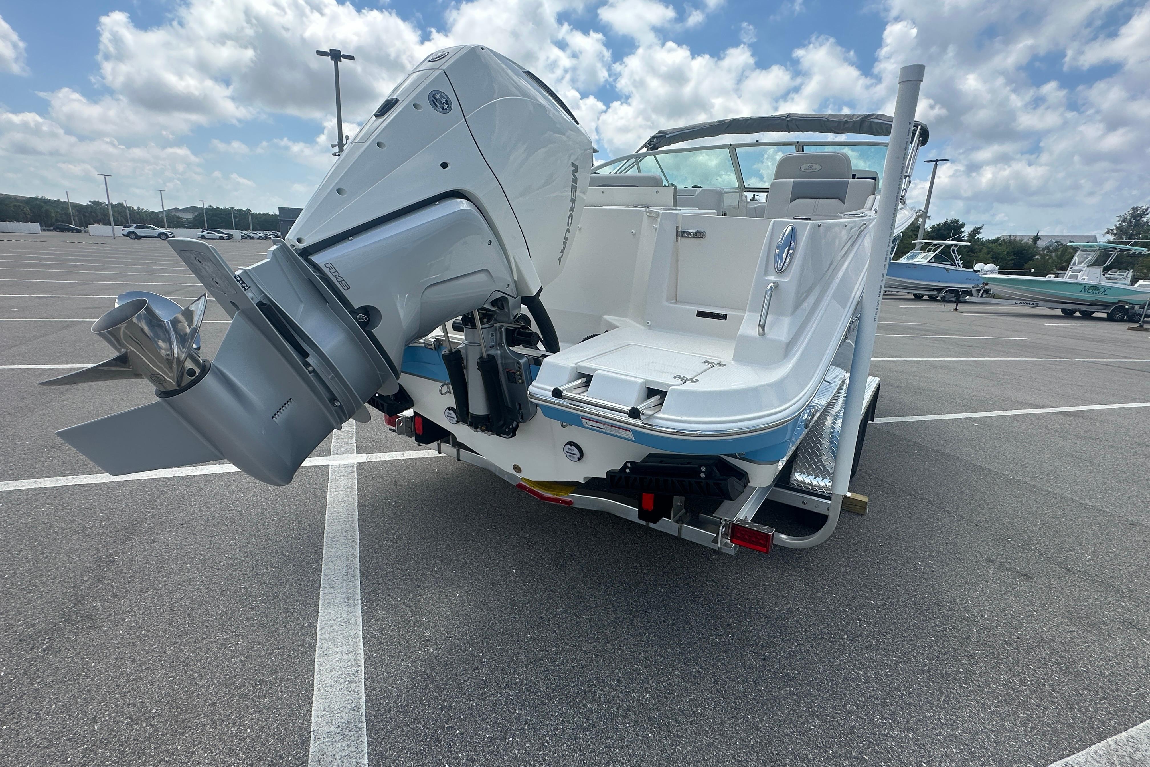 2026 Sailfish 226 DC boat with powerful outboard motor in a parking lot.
