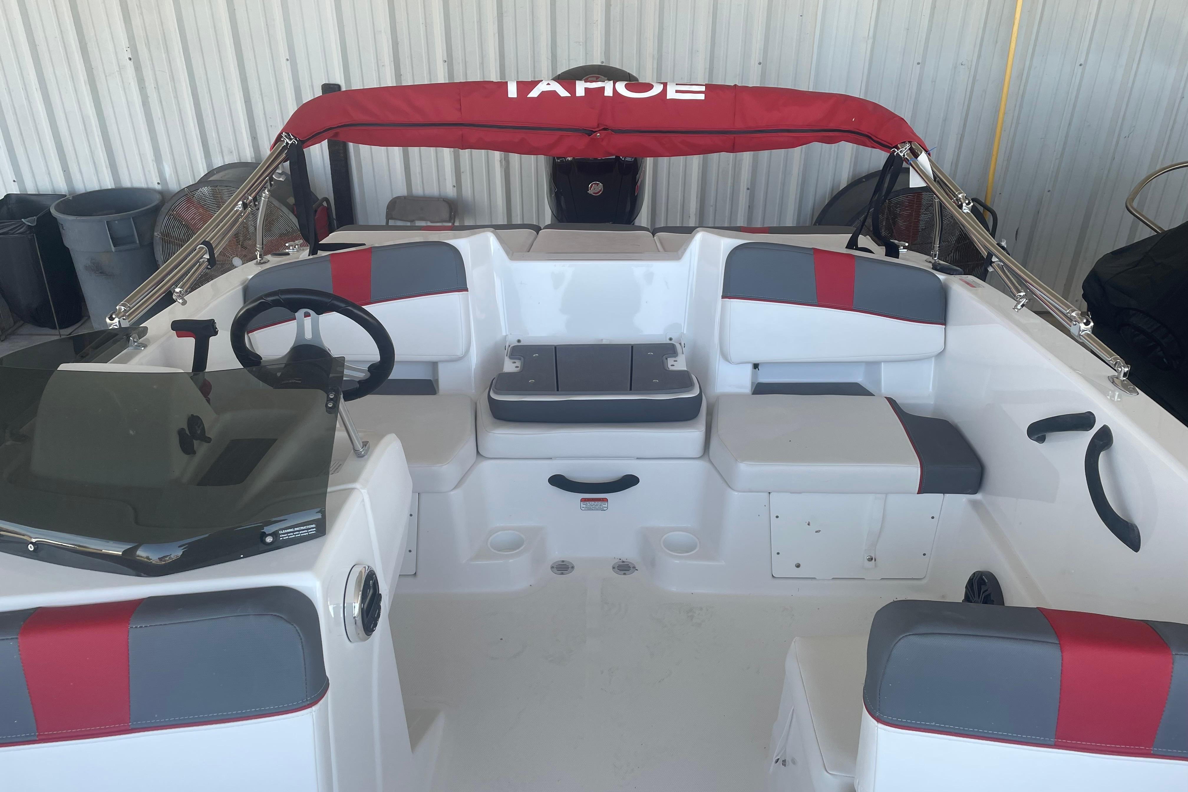 2026 Tahoe T18 boat interior with red and gray seating, steering wheel, and canopy.