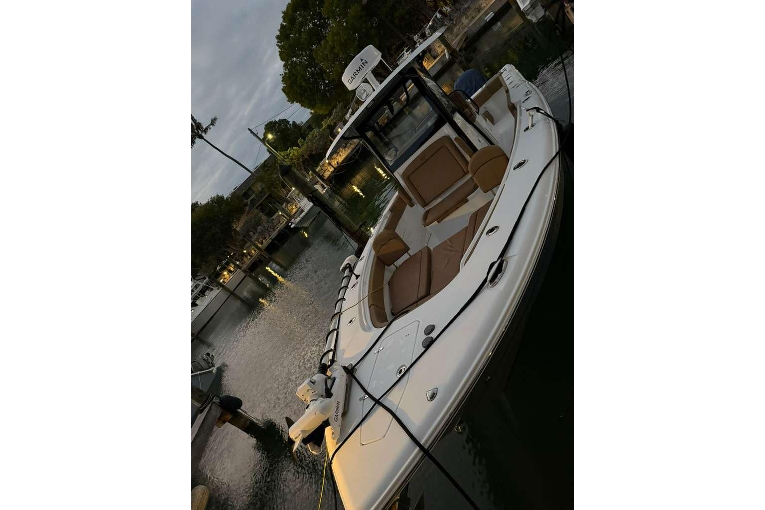 2021 Sea Hunt Gamefish 30 boat docked, featuring forward seating and sleek design.