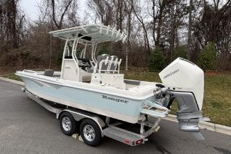 2025 Ranger 2360 Bay boat on trailer, parked outdoors, featuring sleek design and powerful engine.