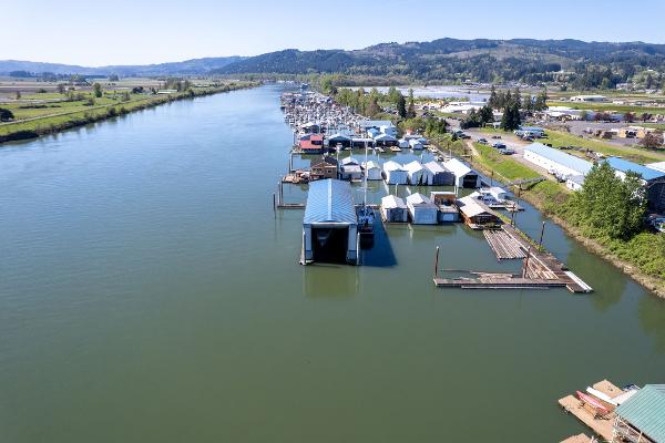 Aerial view of Larson Boathouse, 1985, along a scenic river with surrounding landscape.