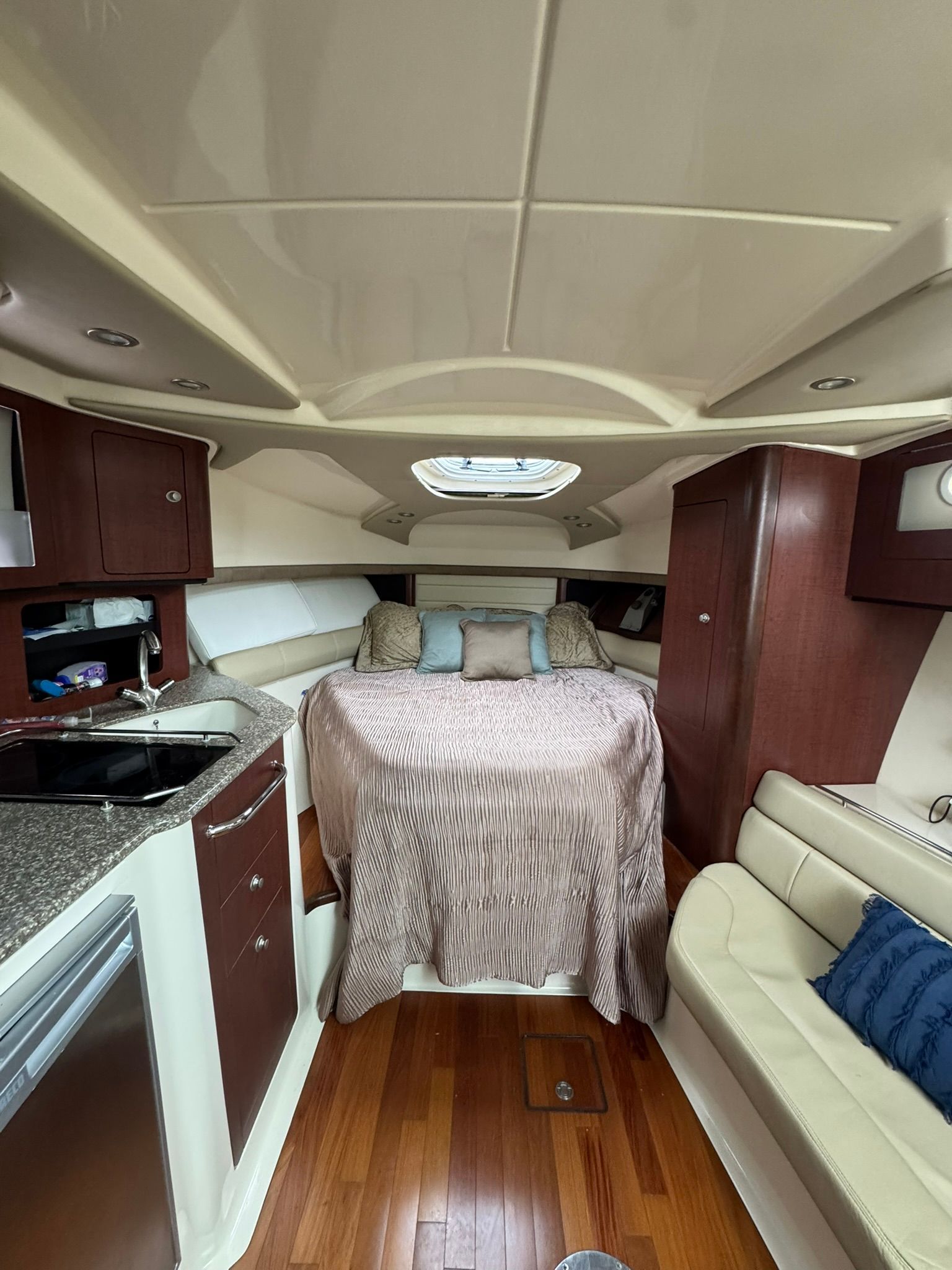 Interior of a 2008 Boston Whaler 345 Conquest with cozy bed and kitchenette.