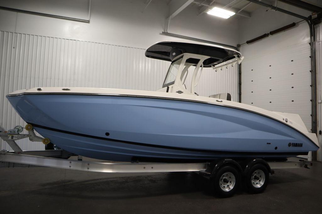 2026 Yamaha Boats 255 FSH Sport E in a showroom, featuring sleek blue design.